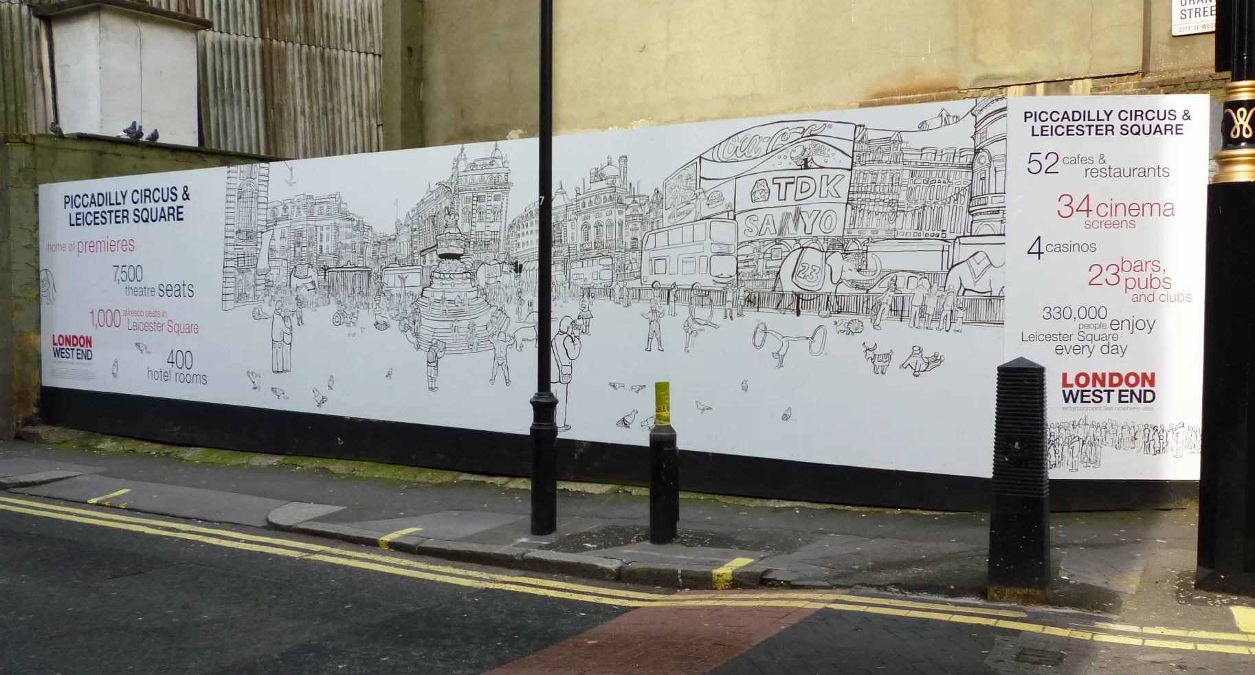 Side profile view of the long-format illustrated street wall stretching across the construction perimeter.