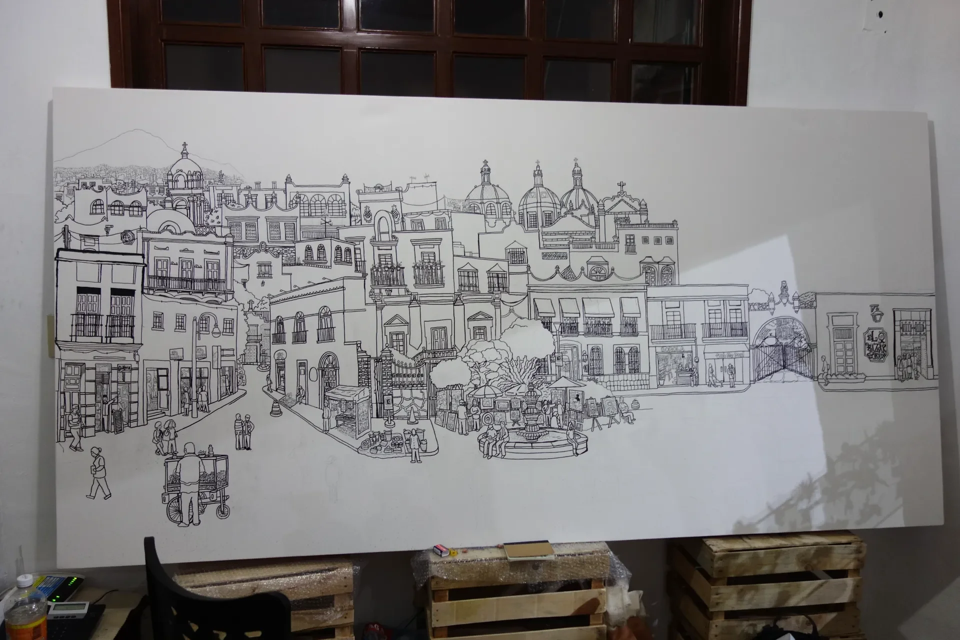 Unframed canvas during production, showing the detailed pen-and-ink cityscape before installation.