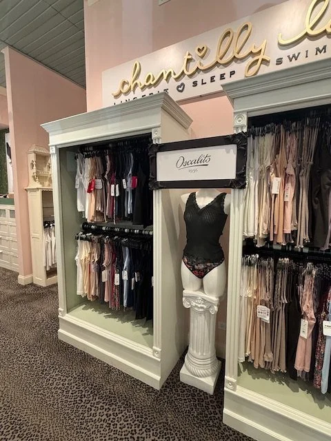 Camisoles and tops on display racks beside a mannequin at Chantilly Lace