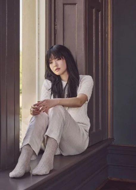 Woman in a window seat wearing oatmeal ribbed knit socks and loungewear