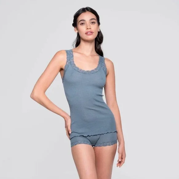 Model in a dusty blue ribbed tank with lace trim and matching shorts