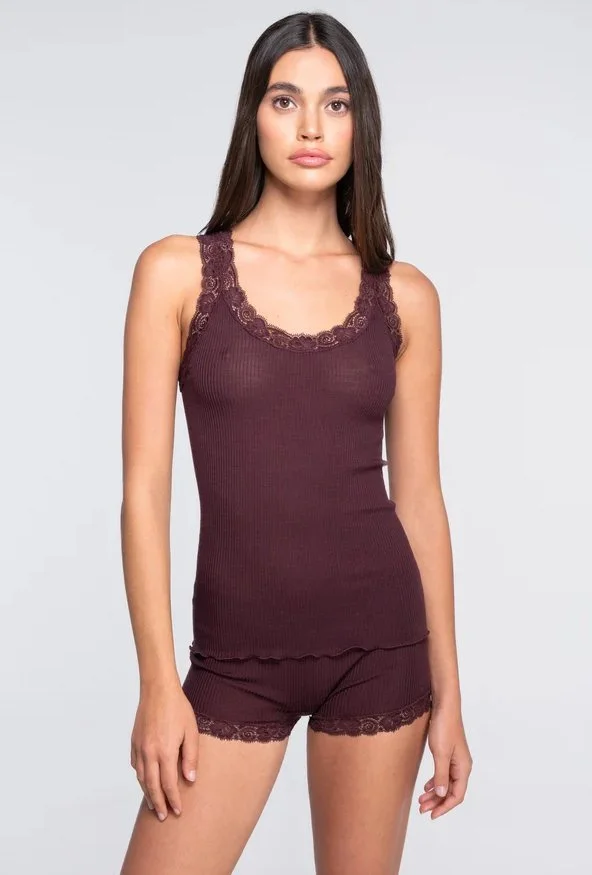 Model in a burgundy ribbed tank with lace trim and matching lace-hem shorts