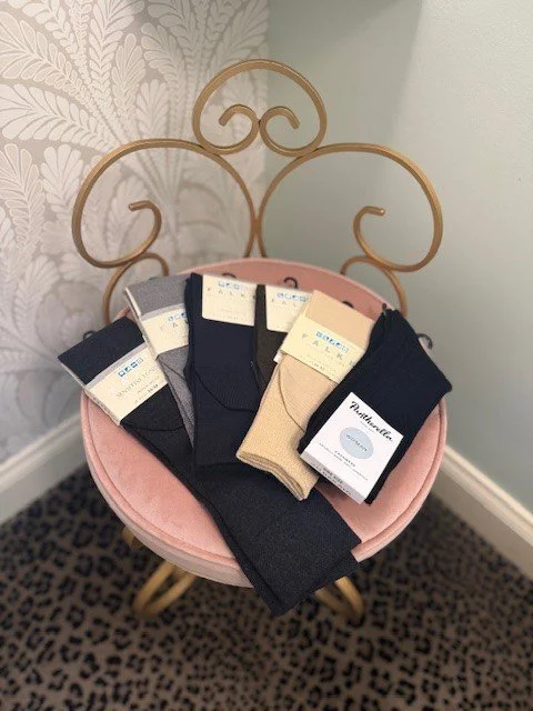 Folded dress socks displayed on a pink velvet chair at Chantilly Lace