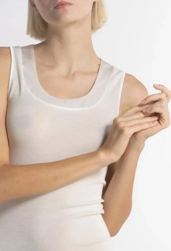 Close-up of an ivory fine-knit tank with a satin-trimmed scoop neckline