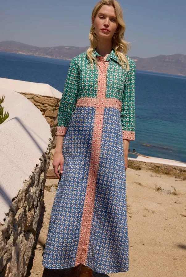 Model in a green, blue and coral patchwork print maxi shirtdress by the sea