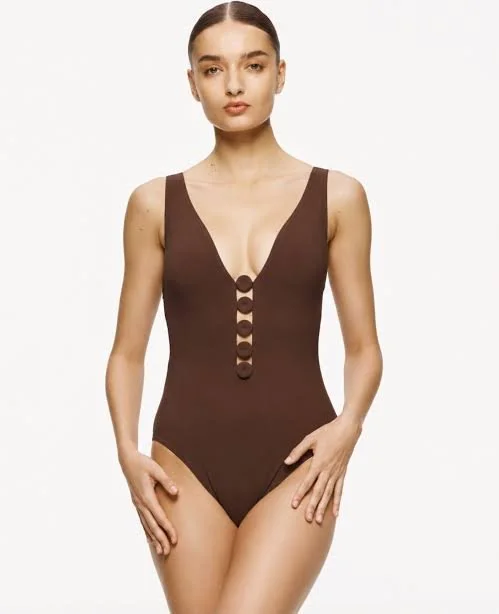 Brown one-piece swimsuit with a decorative plunging neckline, worn