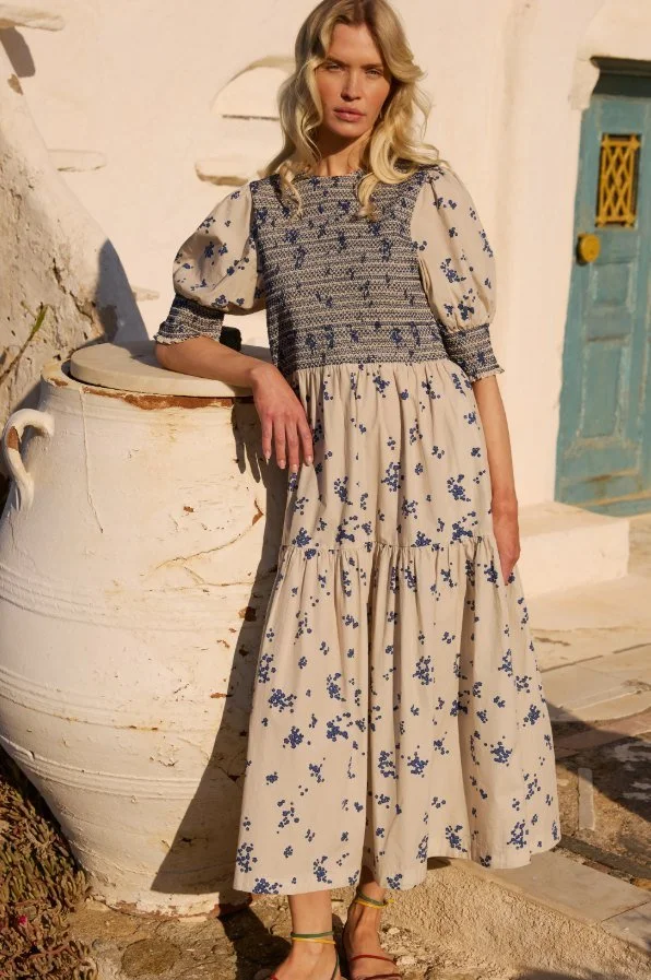 Model in a cream and blue floral maxi dress with a smocked bodice and puff sleeves