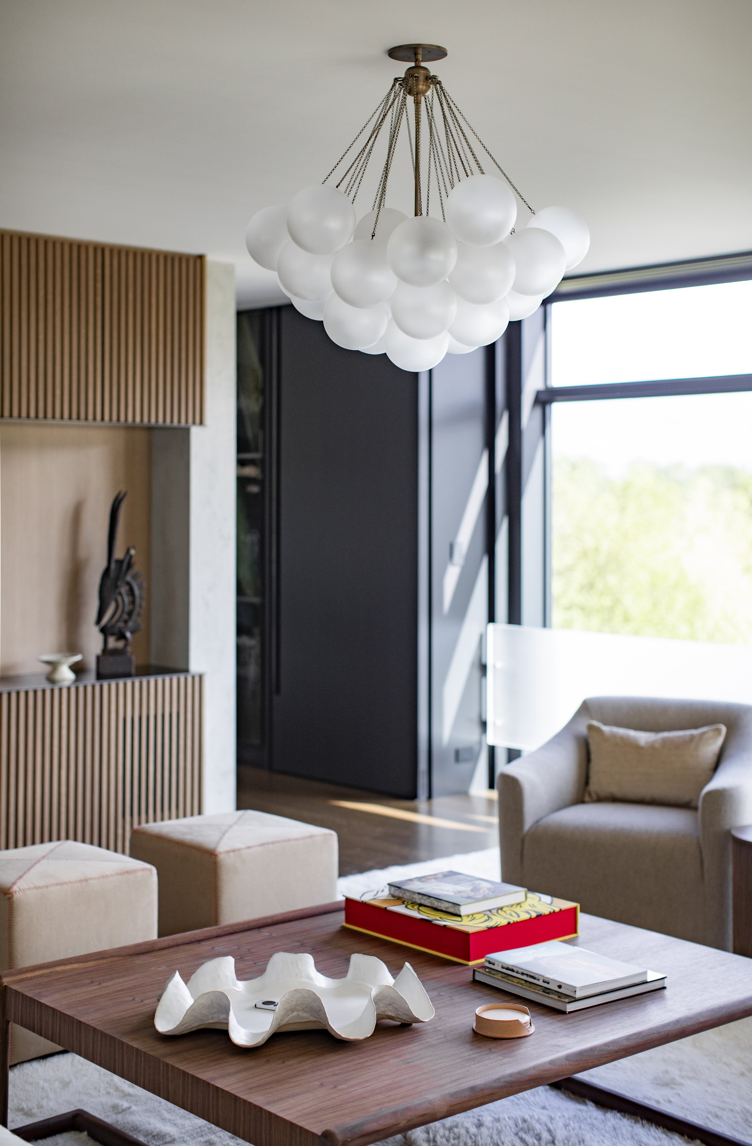 Sitting area with fluted oak panels, a sculpture niche and a cloud-like pendant