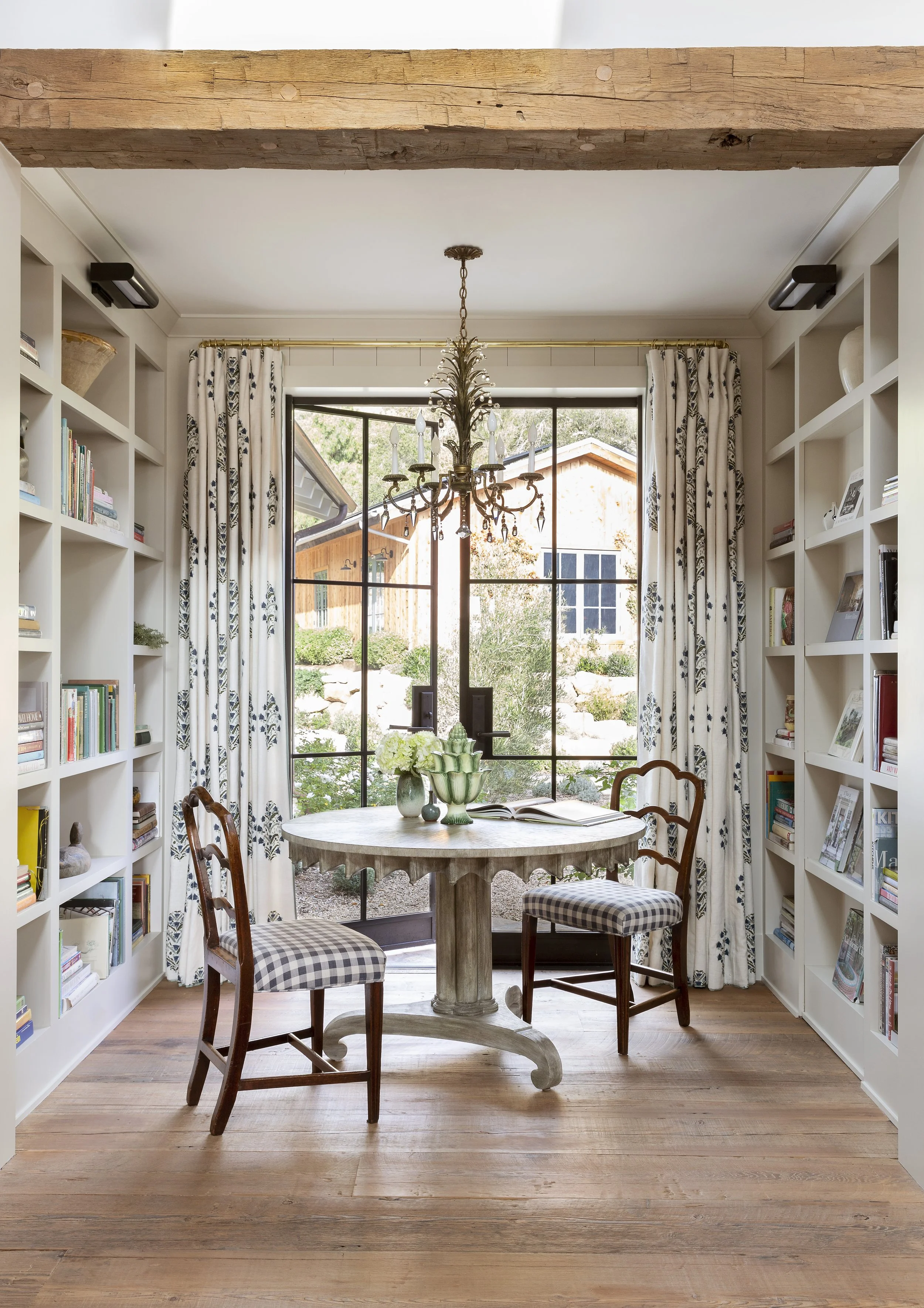 Breakfast nook with steel-framed windows, floral drapes and built-in bookshelves