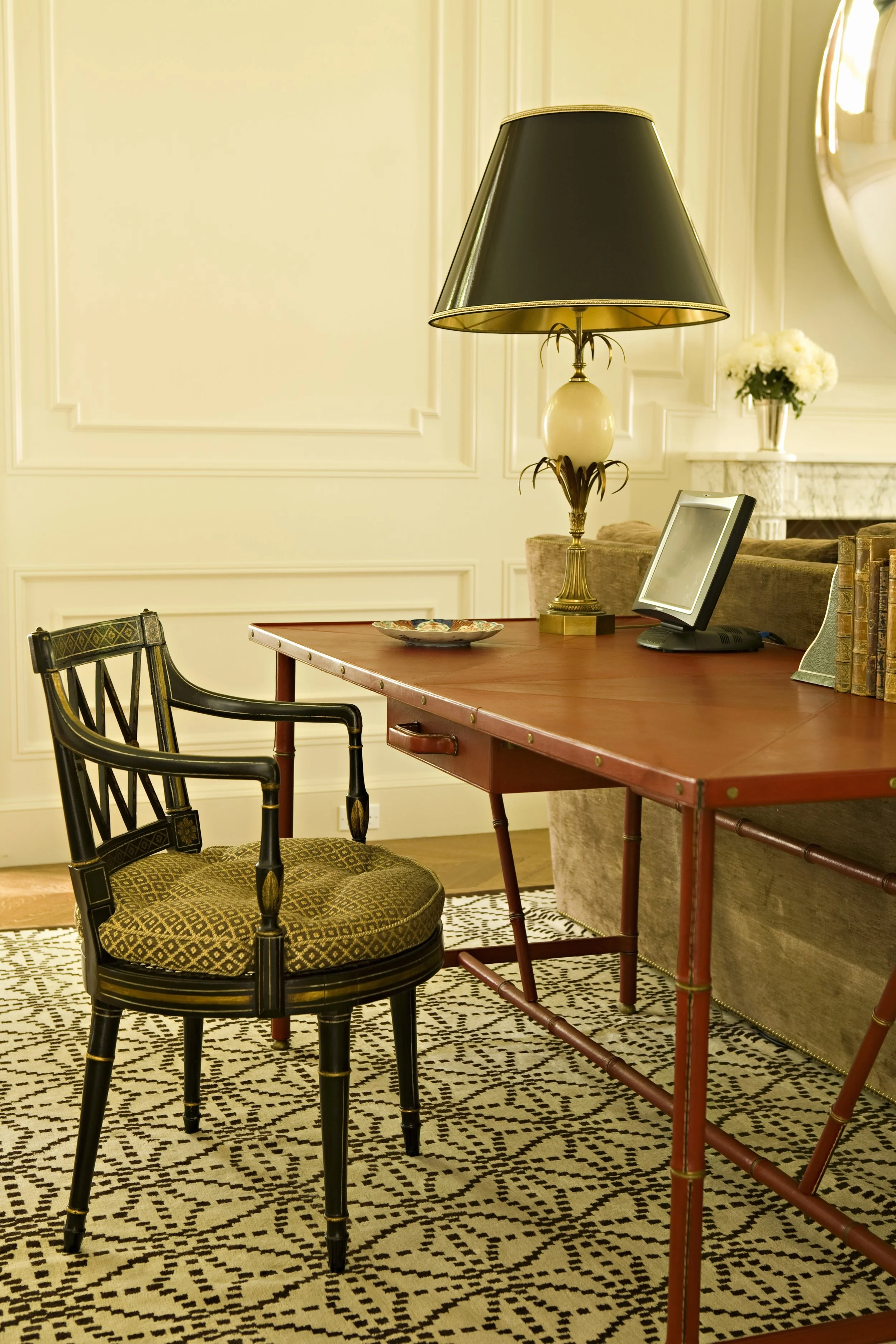 Writing desk with a black Regency chair and a tufted green seat