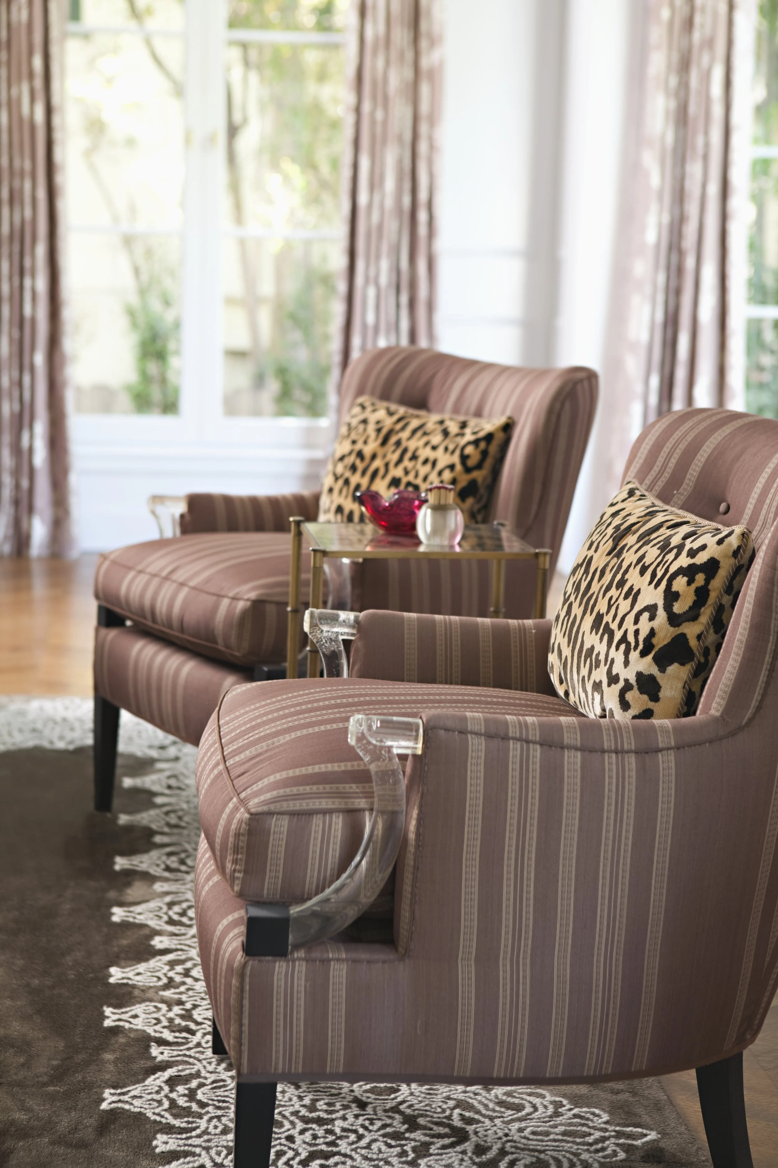 Pair of striped wing chairs with leopard print pillows