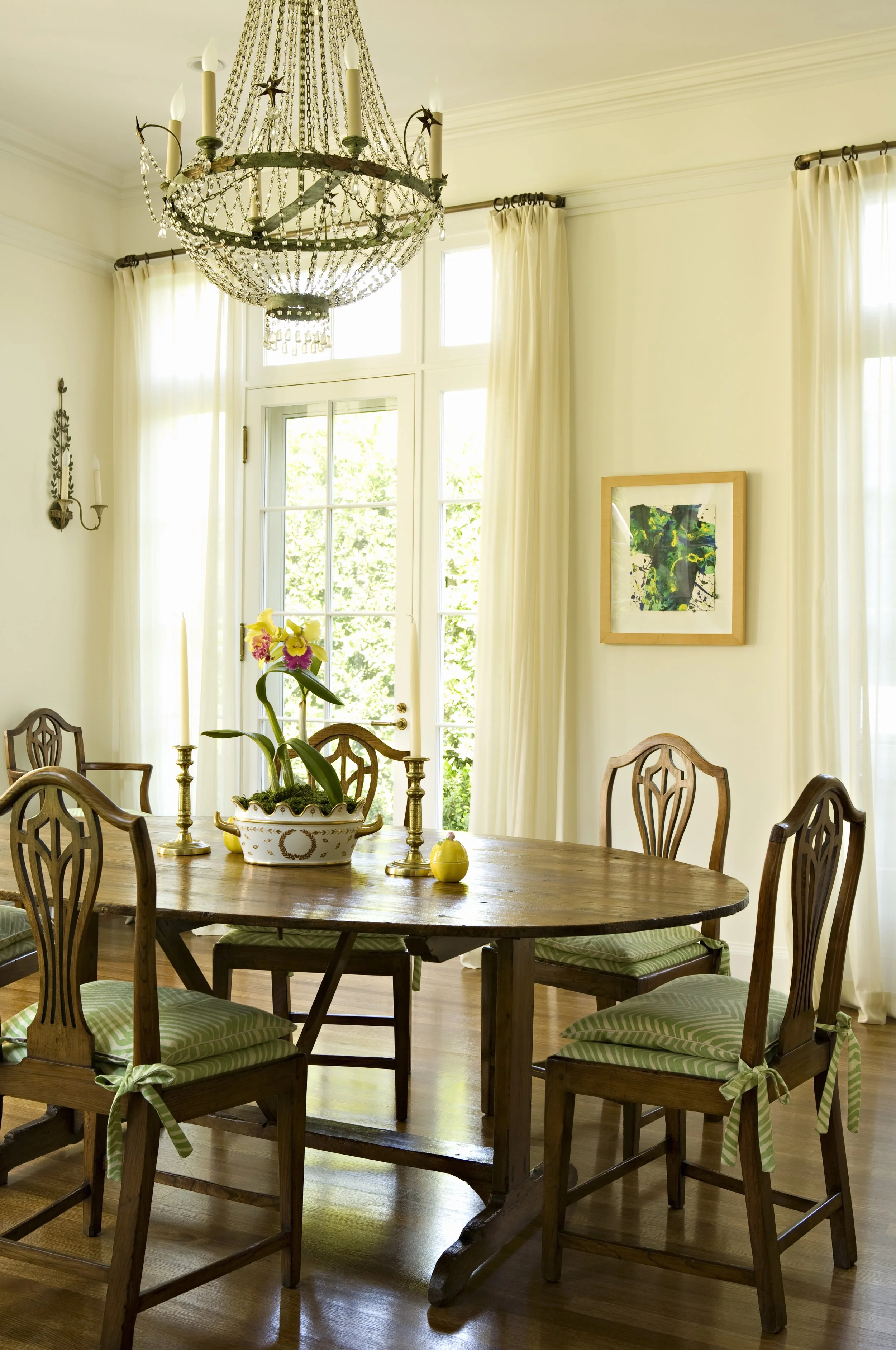Round dining table with Hepplewhite style chairs, an orchid and sunny windows