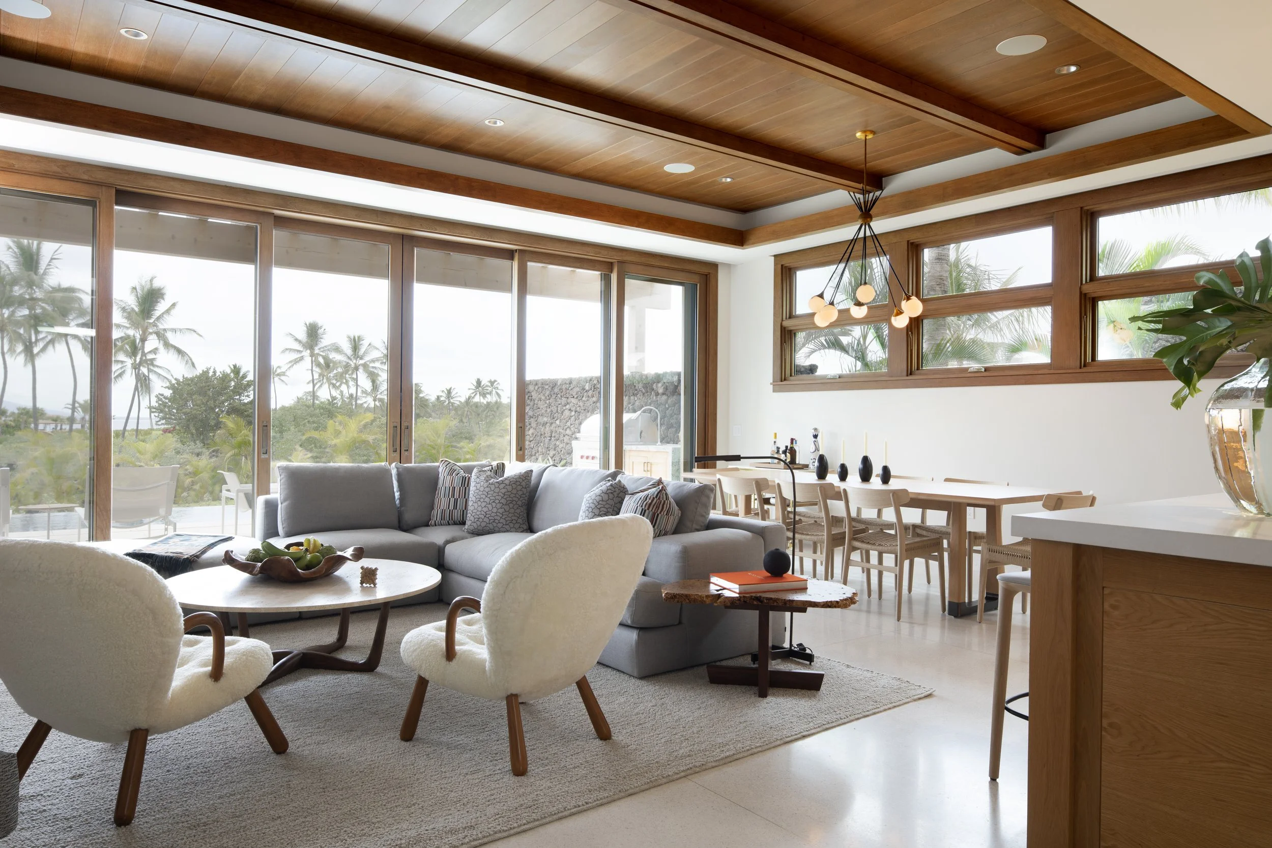 Living and dining area with a wood ceiling and sliding glass doors to the garden