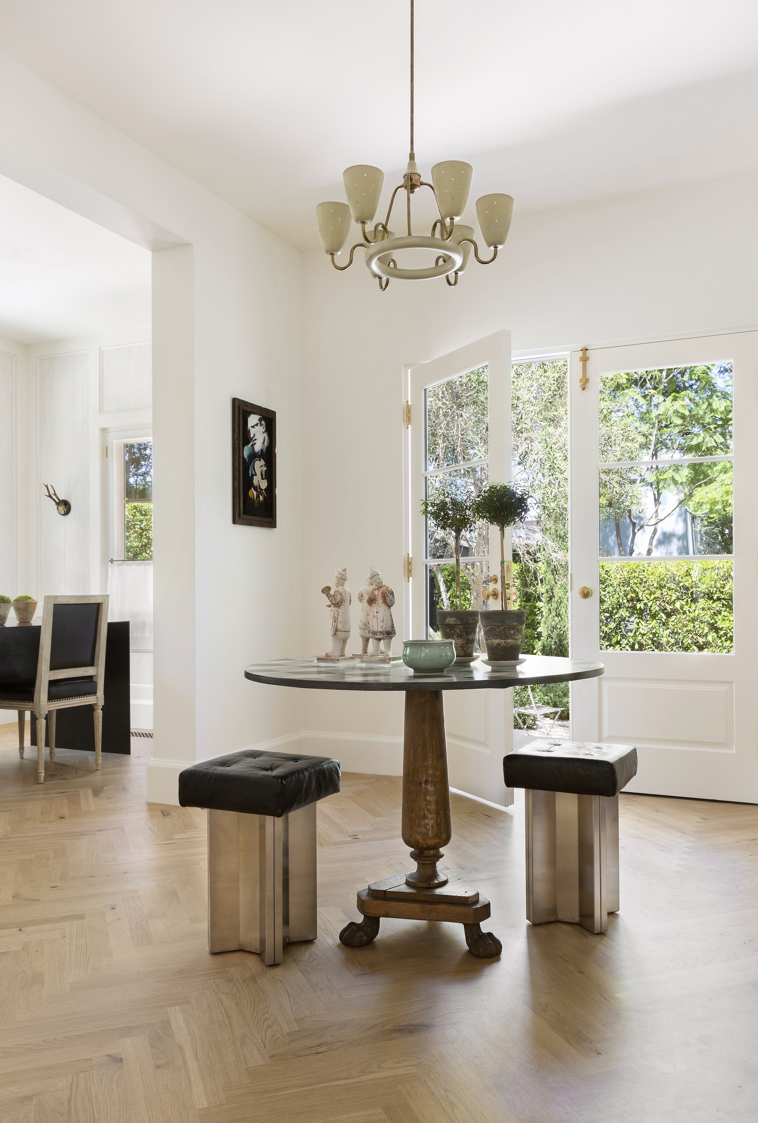 Sitting nook with a glass table, black stools and large windows