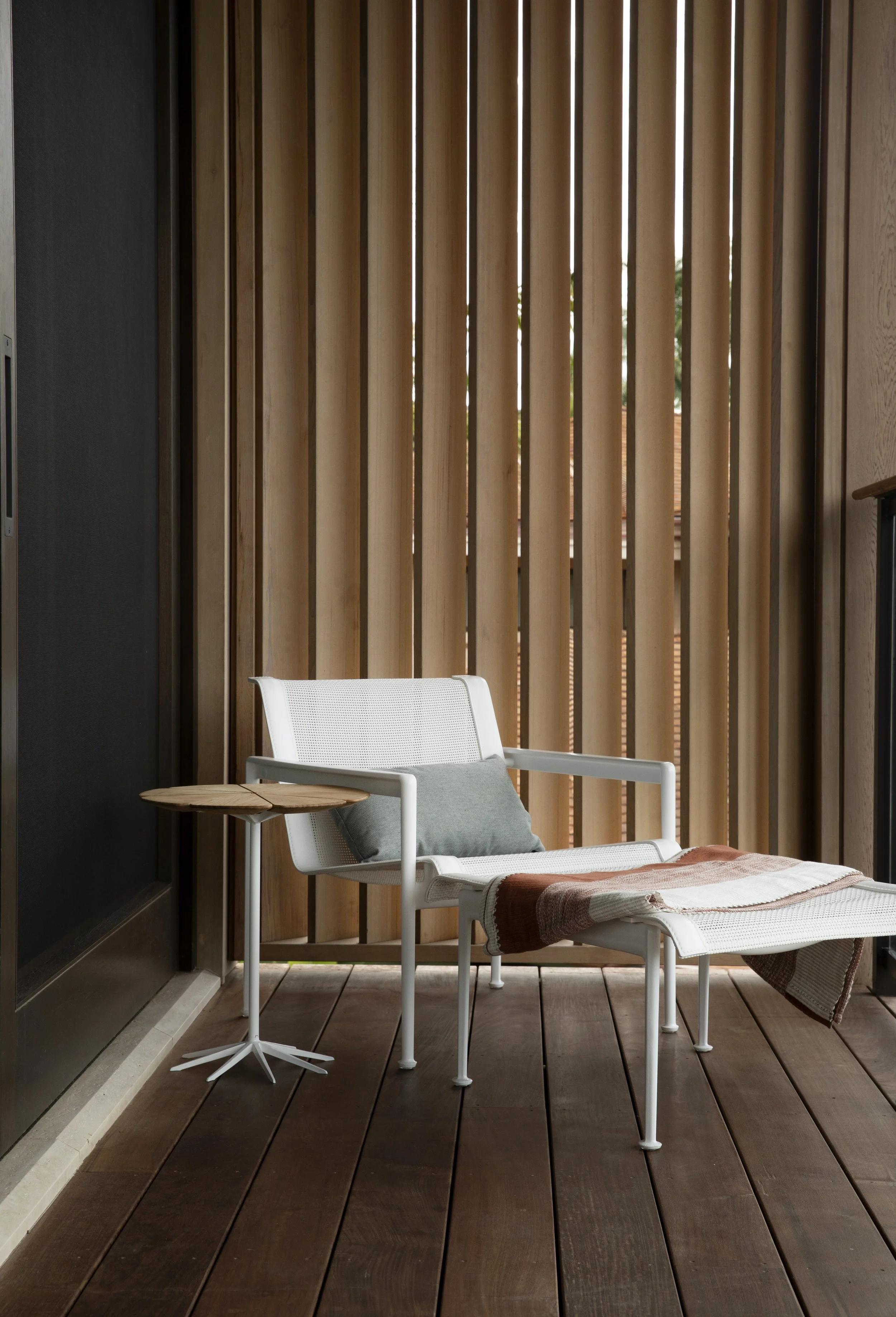 Balcony lounge chair behind wood slat screens