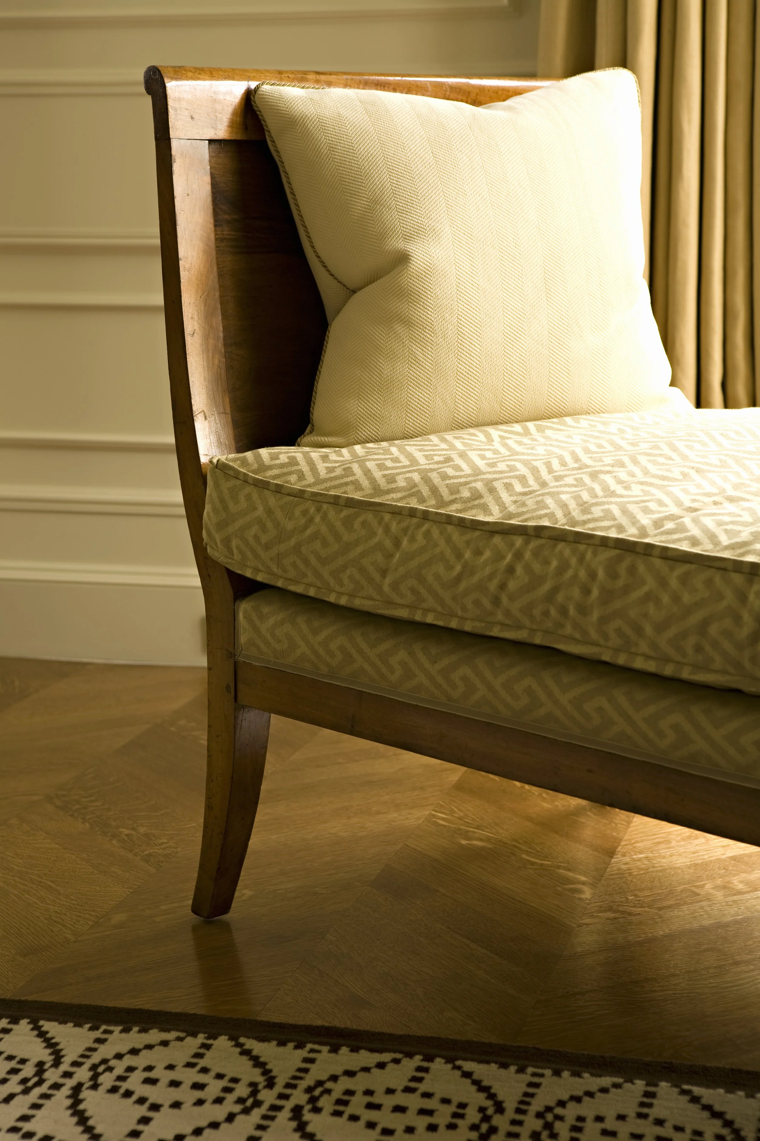 Detail of an upholstered green bench cushion in geometric fabric