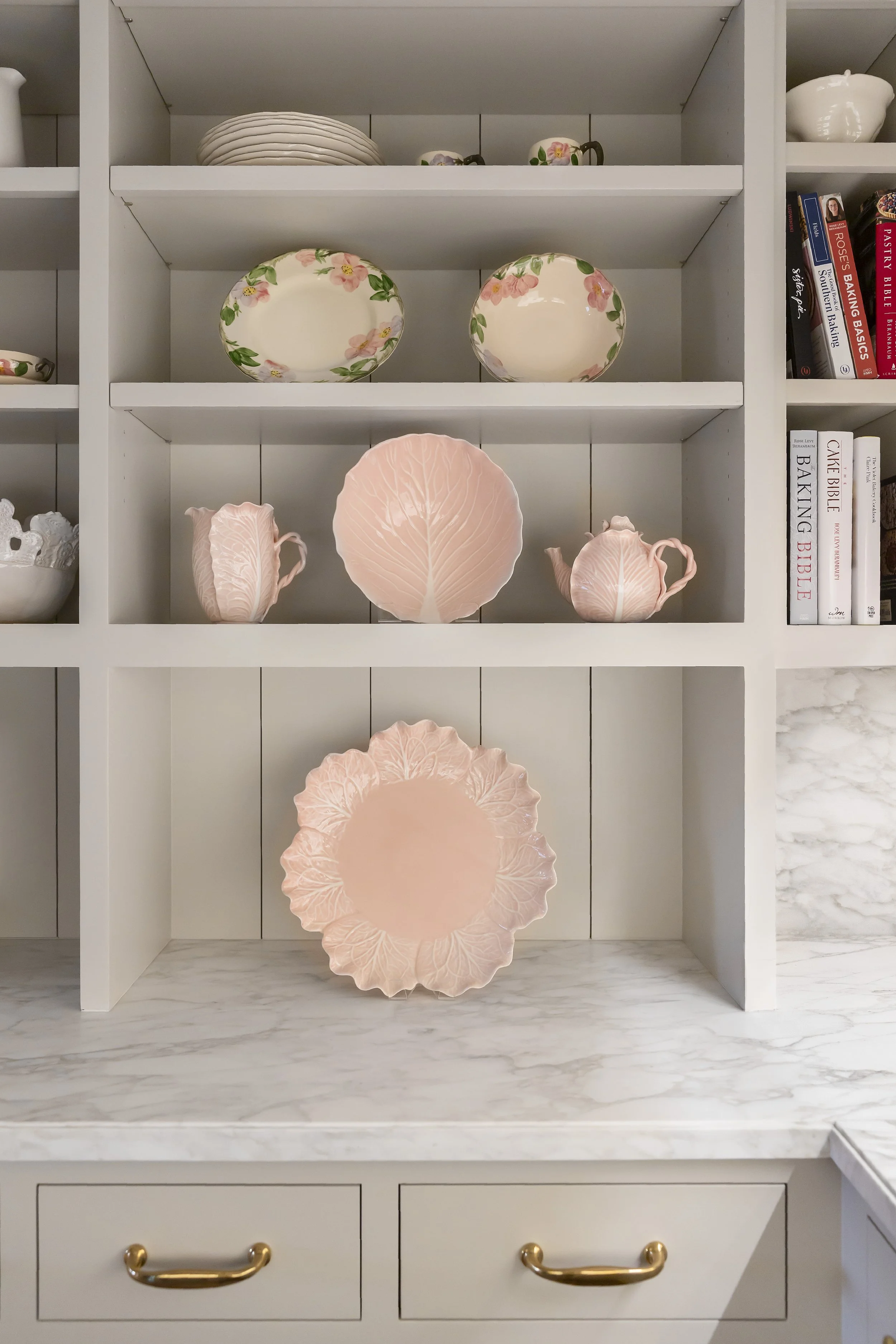 Built-in shelving with pink ceramic plates and teapots