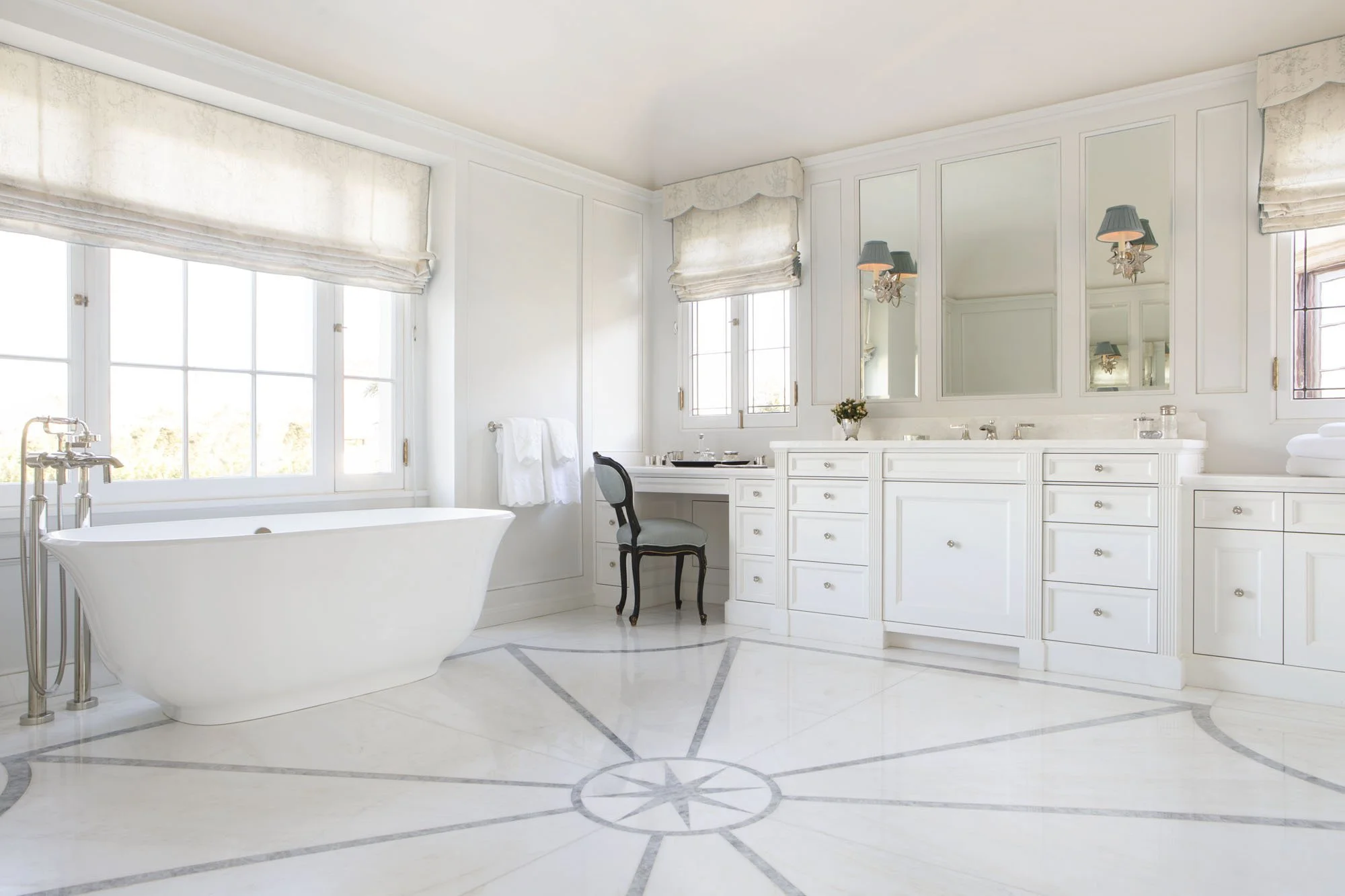 White primary bath with freestanding tub, built-in vanity and star inlay marble floor