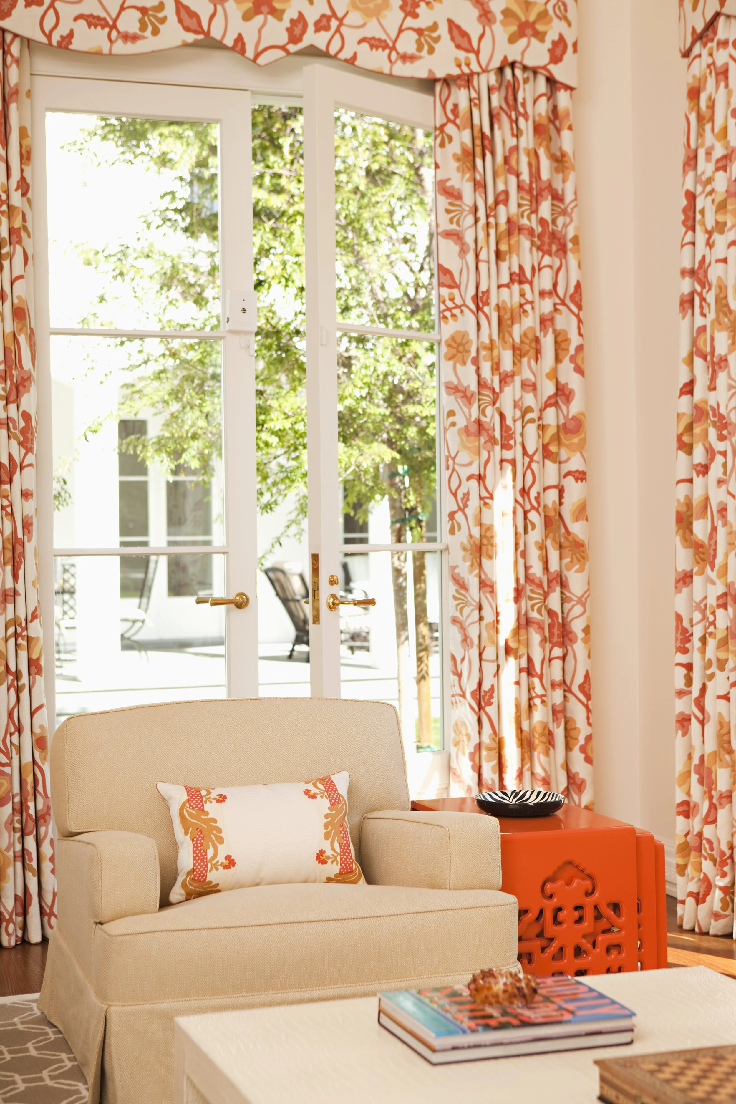 French doors with coral floral drapes opening to a patio