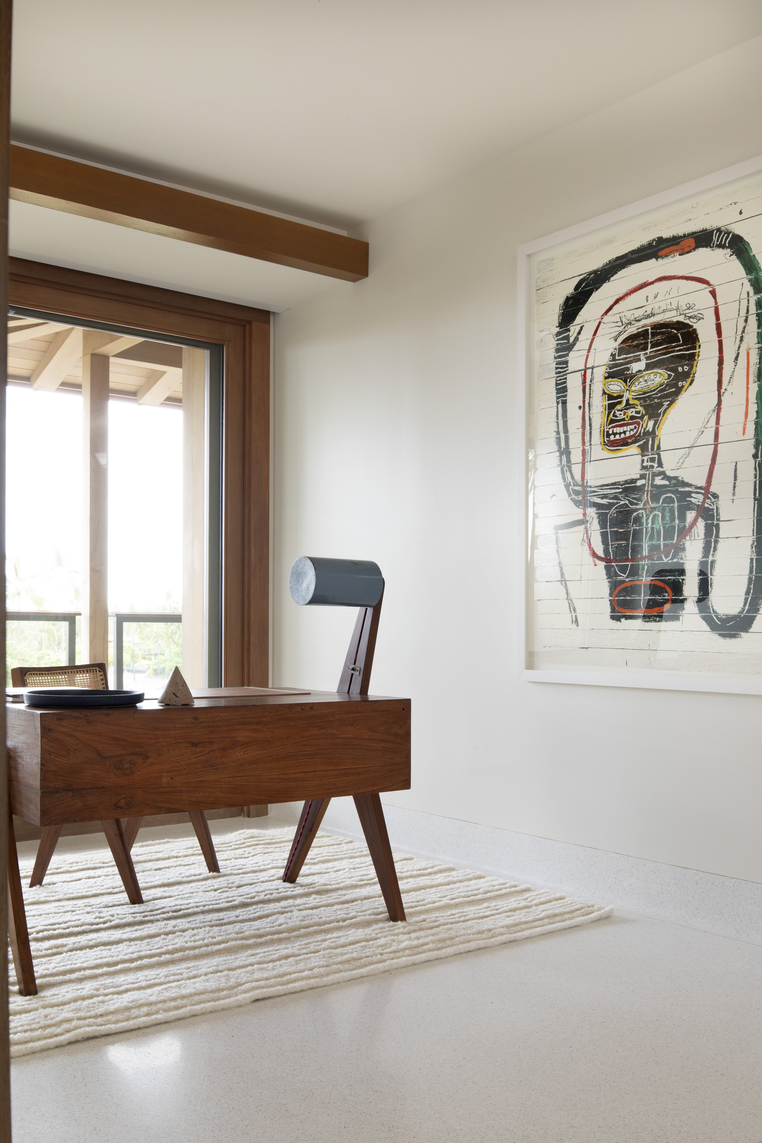 Study corner with a walnut desk and an expressive portrait painting