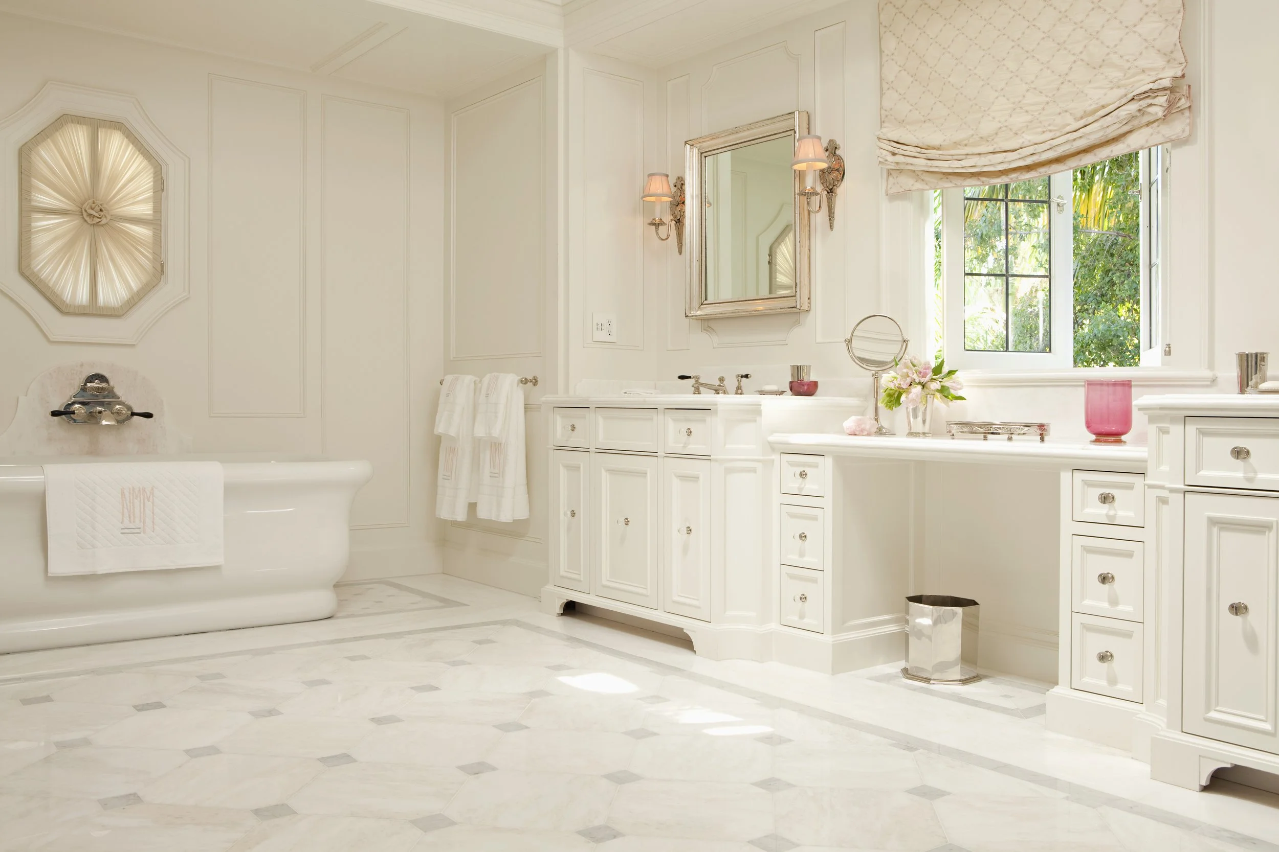 White bath with a freestanding tub, dressing table vanity and octagon pattern tile floor