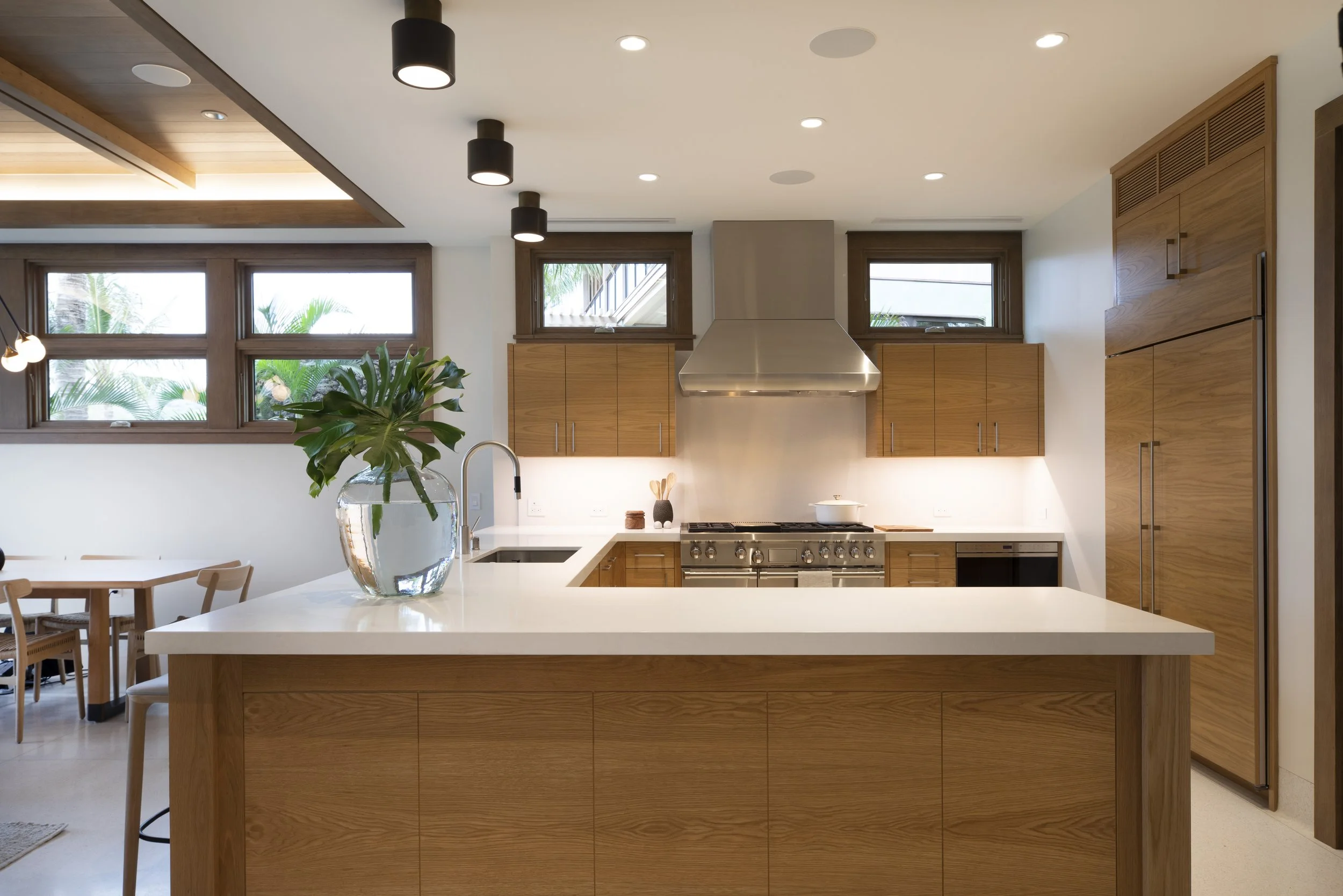 Kitchen with oak cabinets, white counters and a stainless range hood