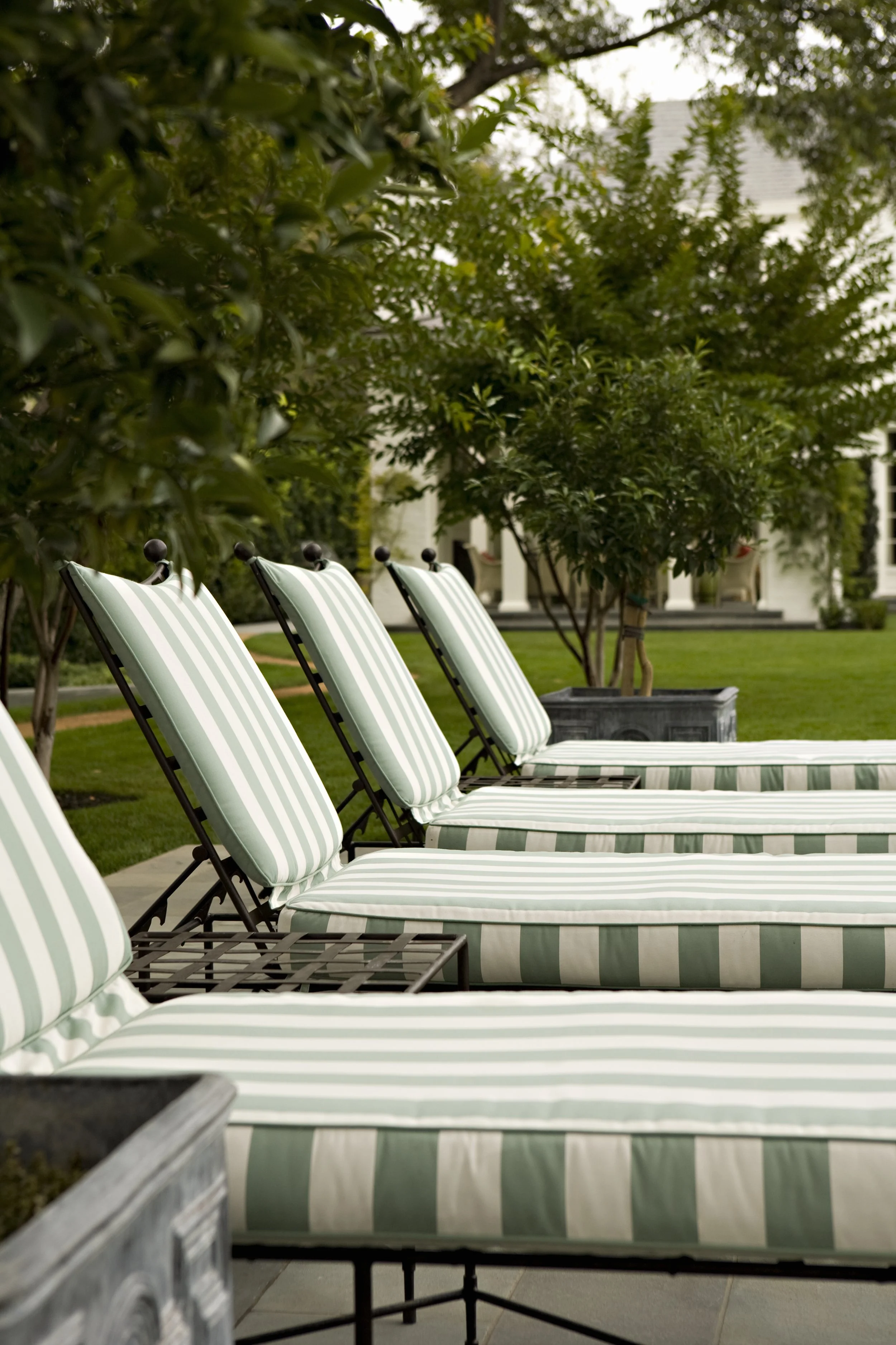 Green and white striped lounge chairs on the lawn