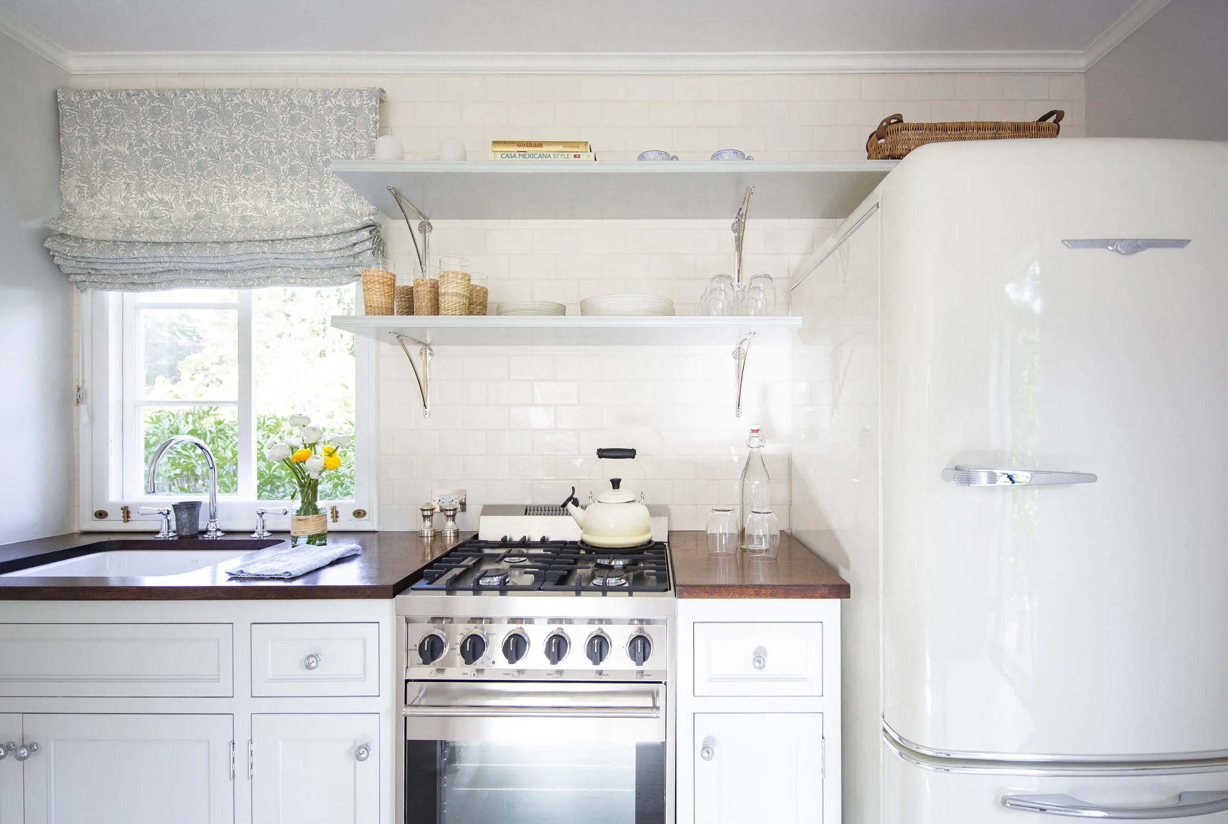 Compact kitchenette with white cabinetry, dark wood counters, a retro cream refrigerator, a range and open shelving
