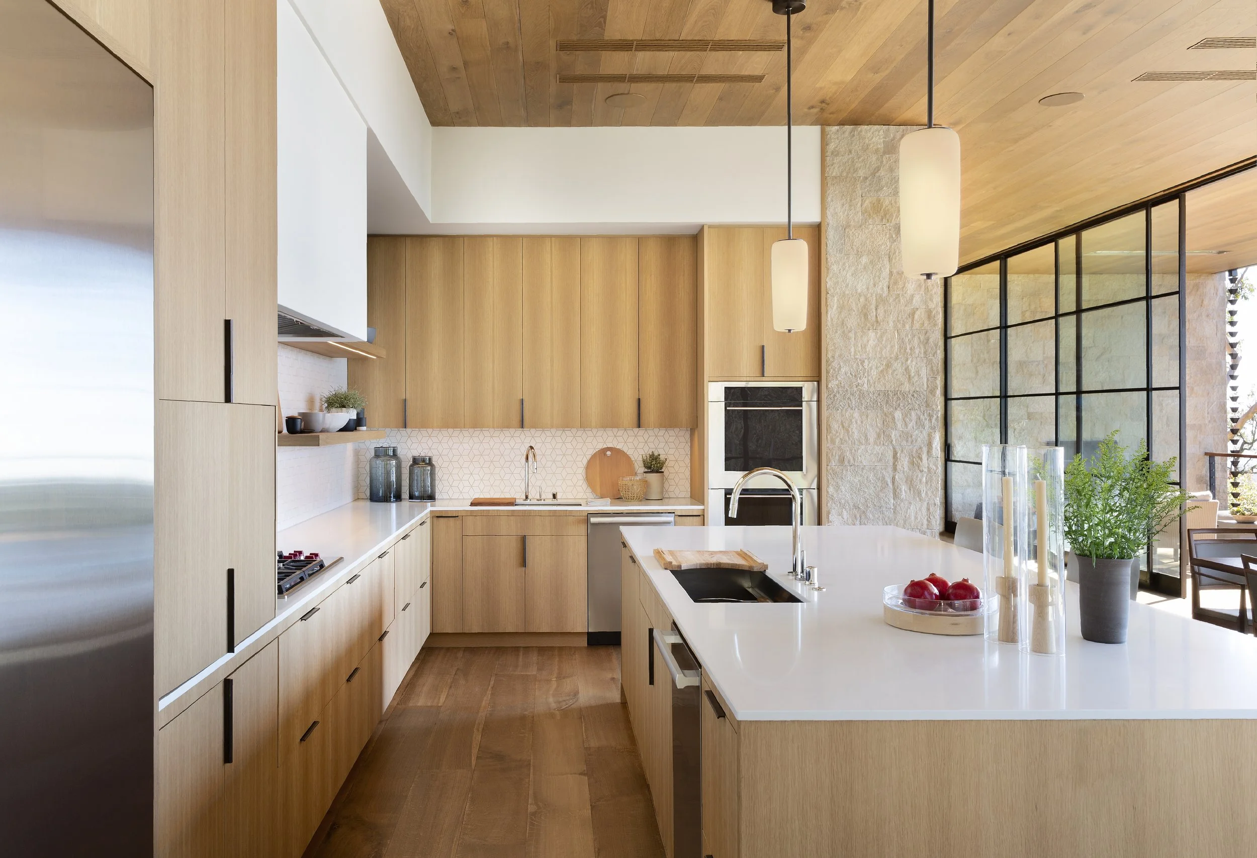 Kitchen with white oak cabinetry, a quartz island and steel-framed windows