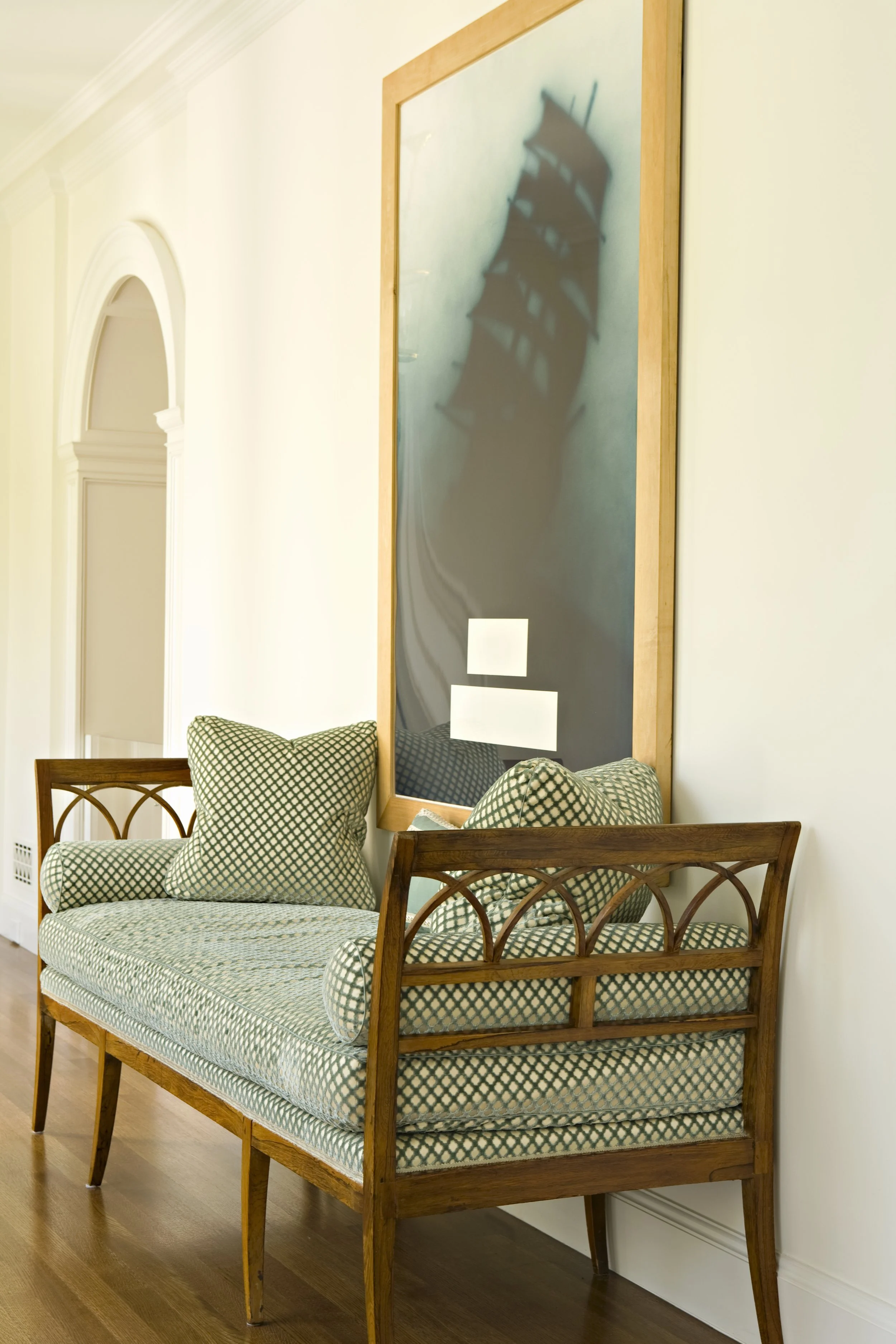 Bench with green checked pillows below a framed chalkboard
