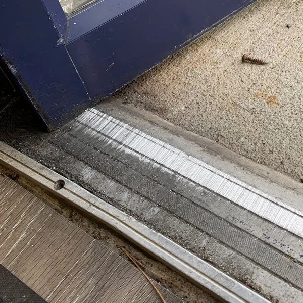 Worn bottom edge and threshold of a commercial door
