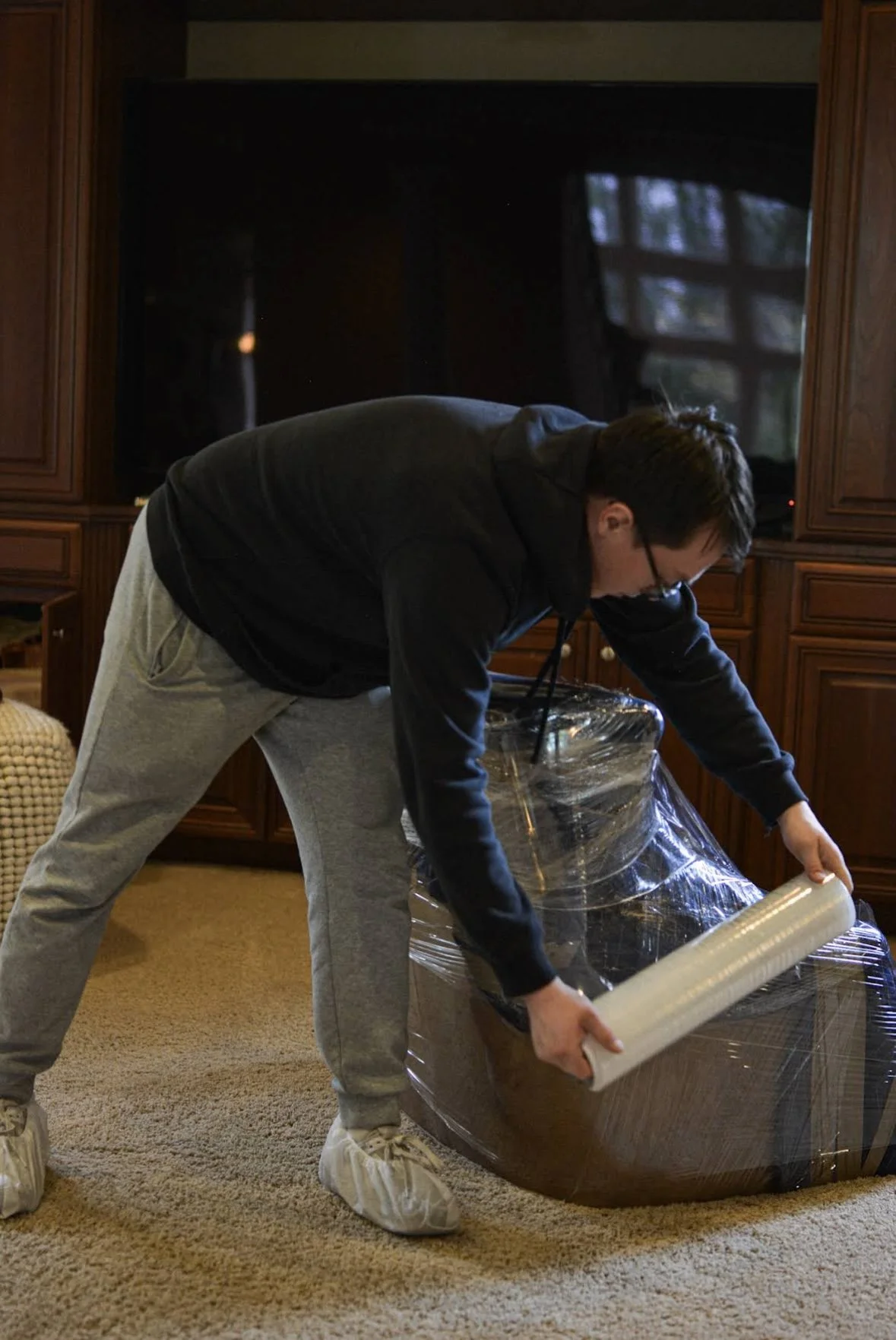 Furniture being protected with plastic stretch wrap before moving.