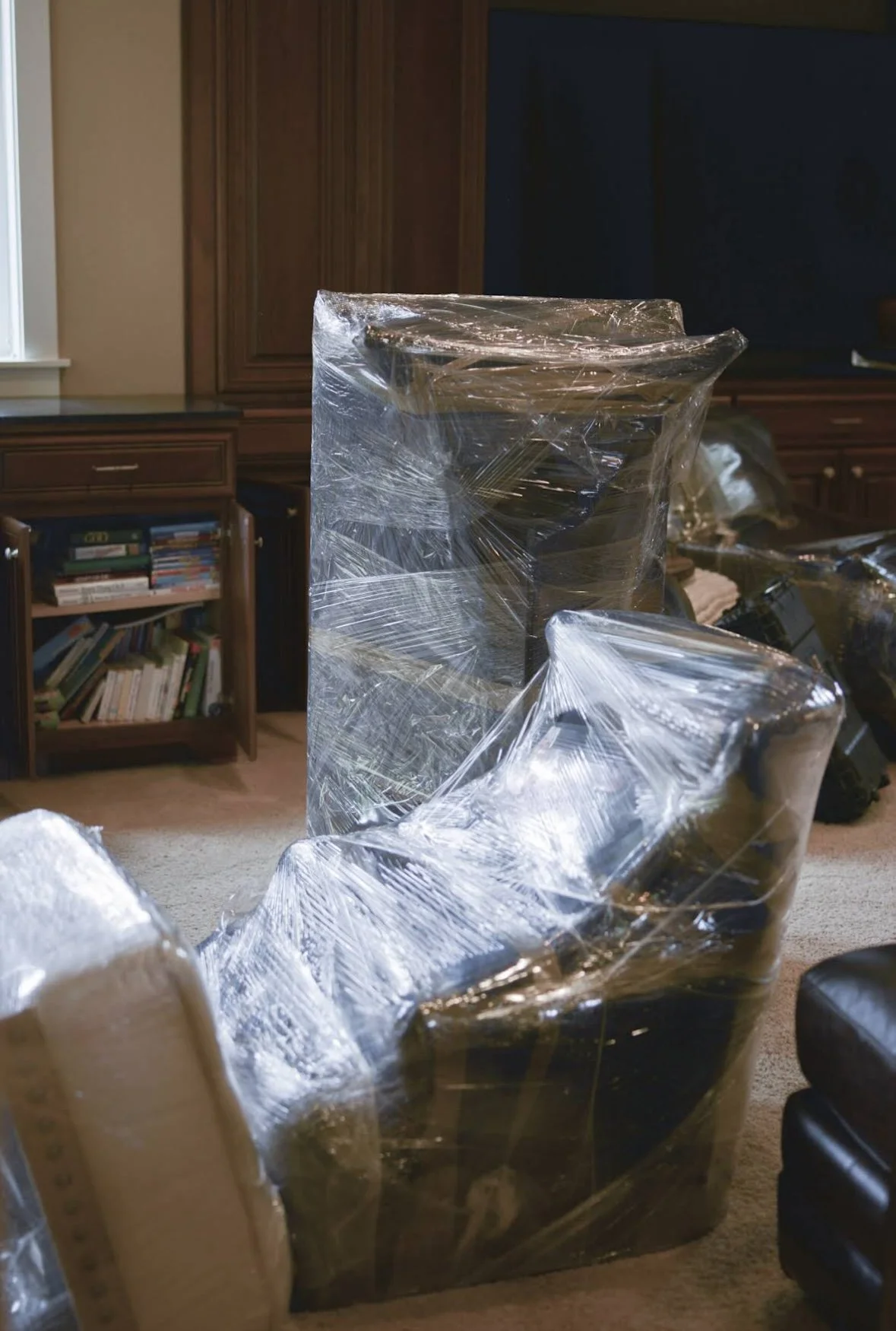 Household furniture wrapped in protective plastic for a residential move.