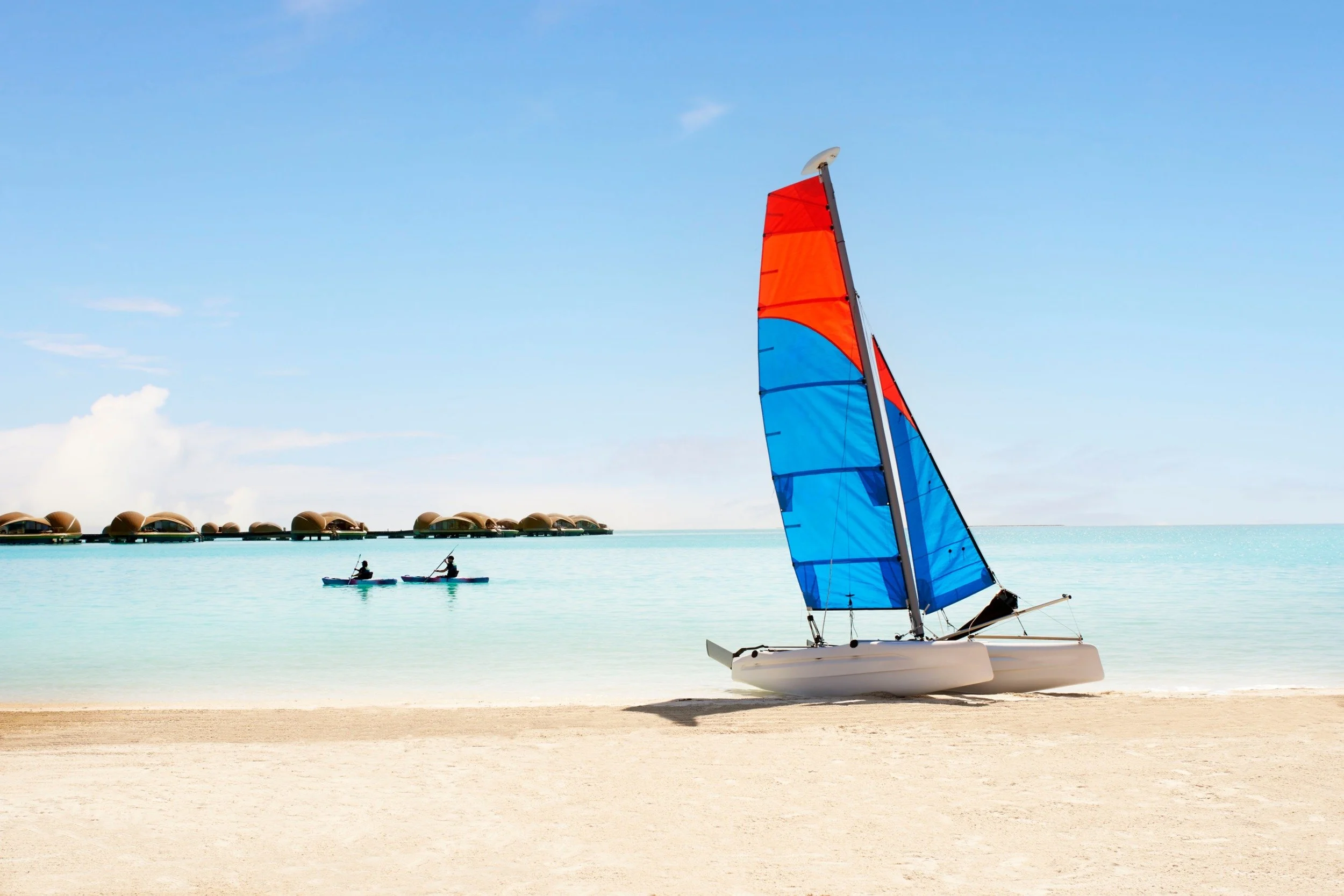31-sailboat-and-kayakers-by-the-beach.jpg