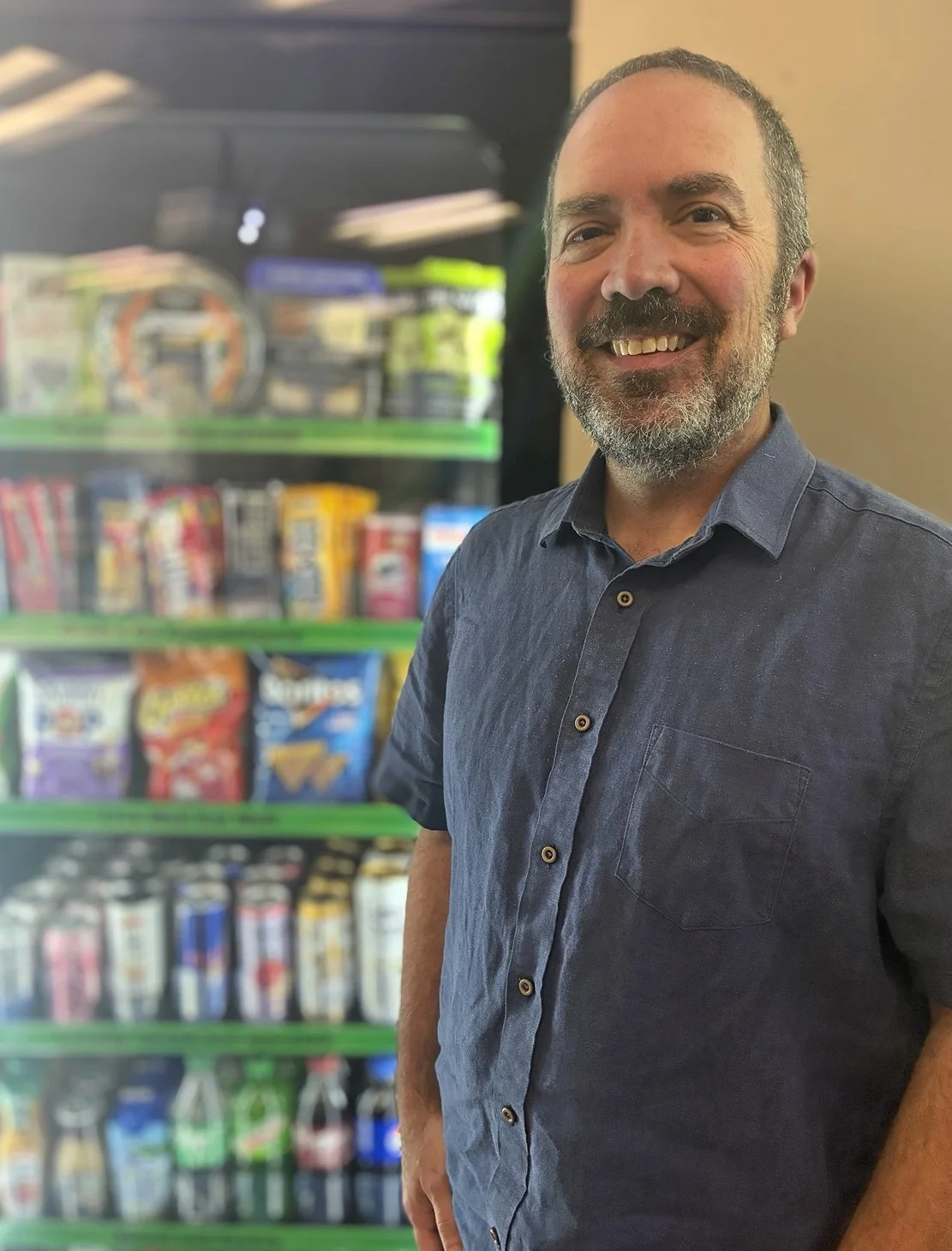 Todd Metzger, owner of TM Markets, next to a stocked SmartMart cooler