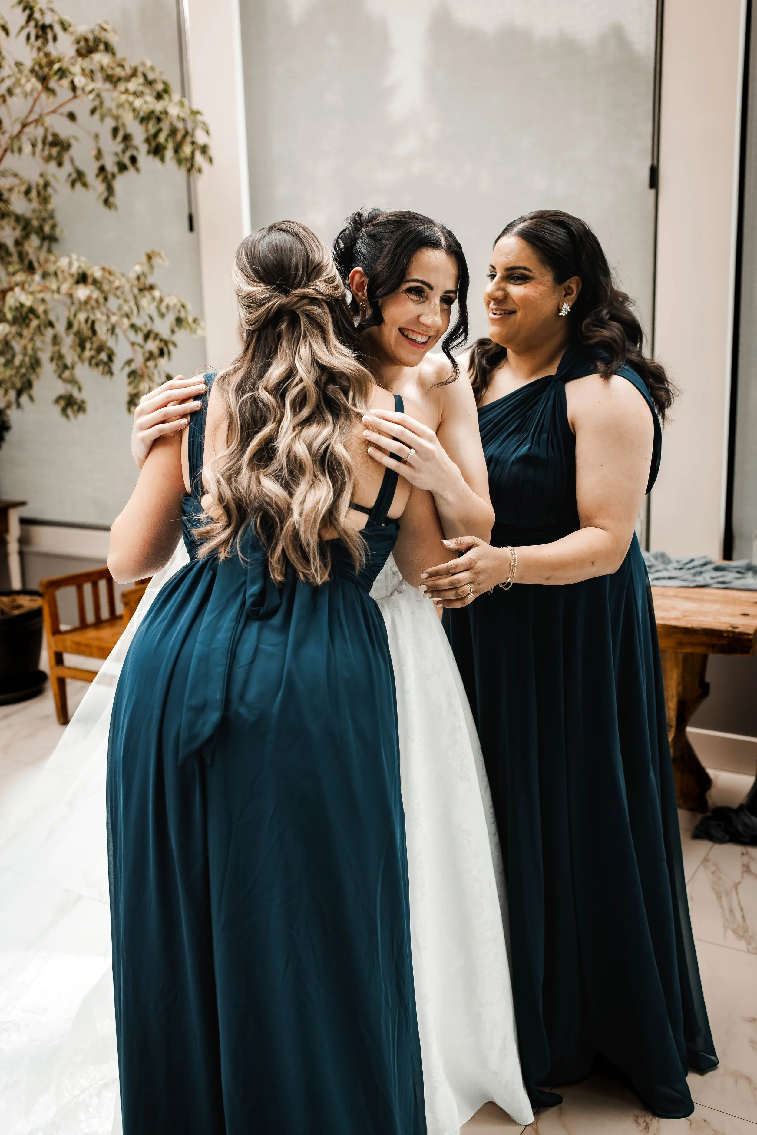 Bride embracing her bridesmaid during an emotional getting-ready moment.