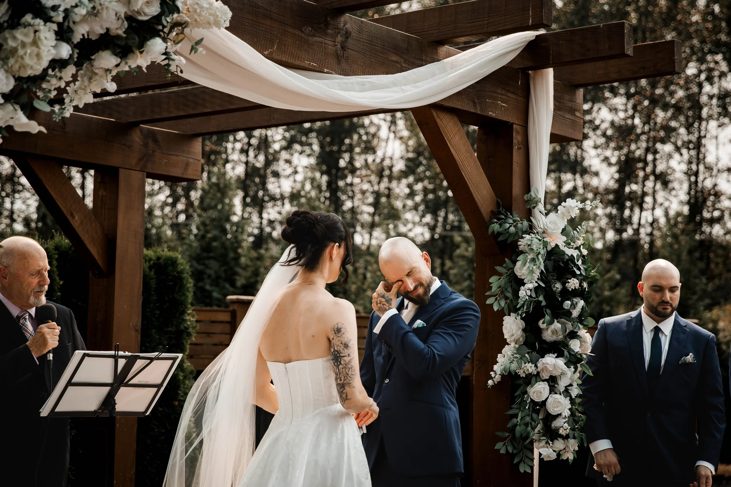 Groom wiping away tears during an emotional outdoor wedding ceremony at Bridlewoods.