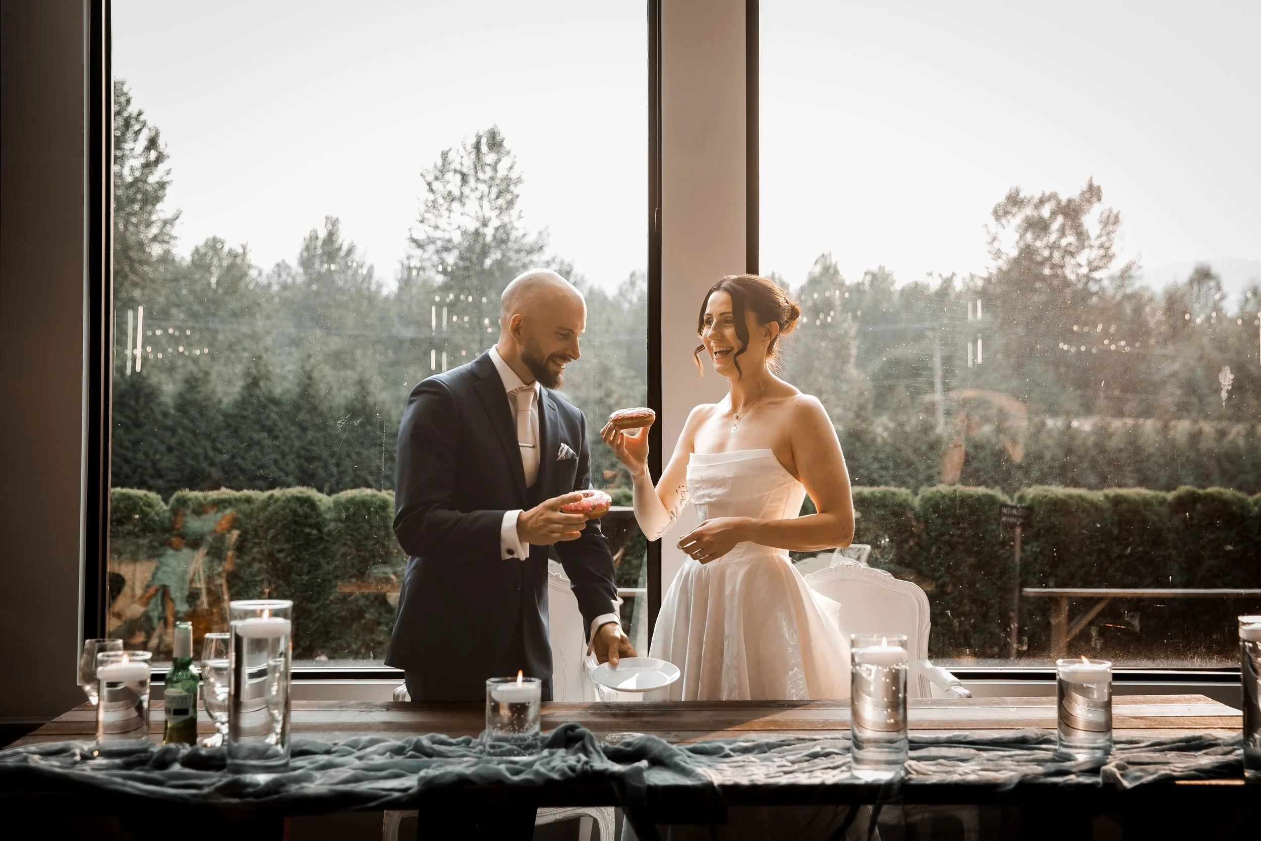 Bride and groom sharing a quiet moment together beside a window during their wedding reception.