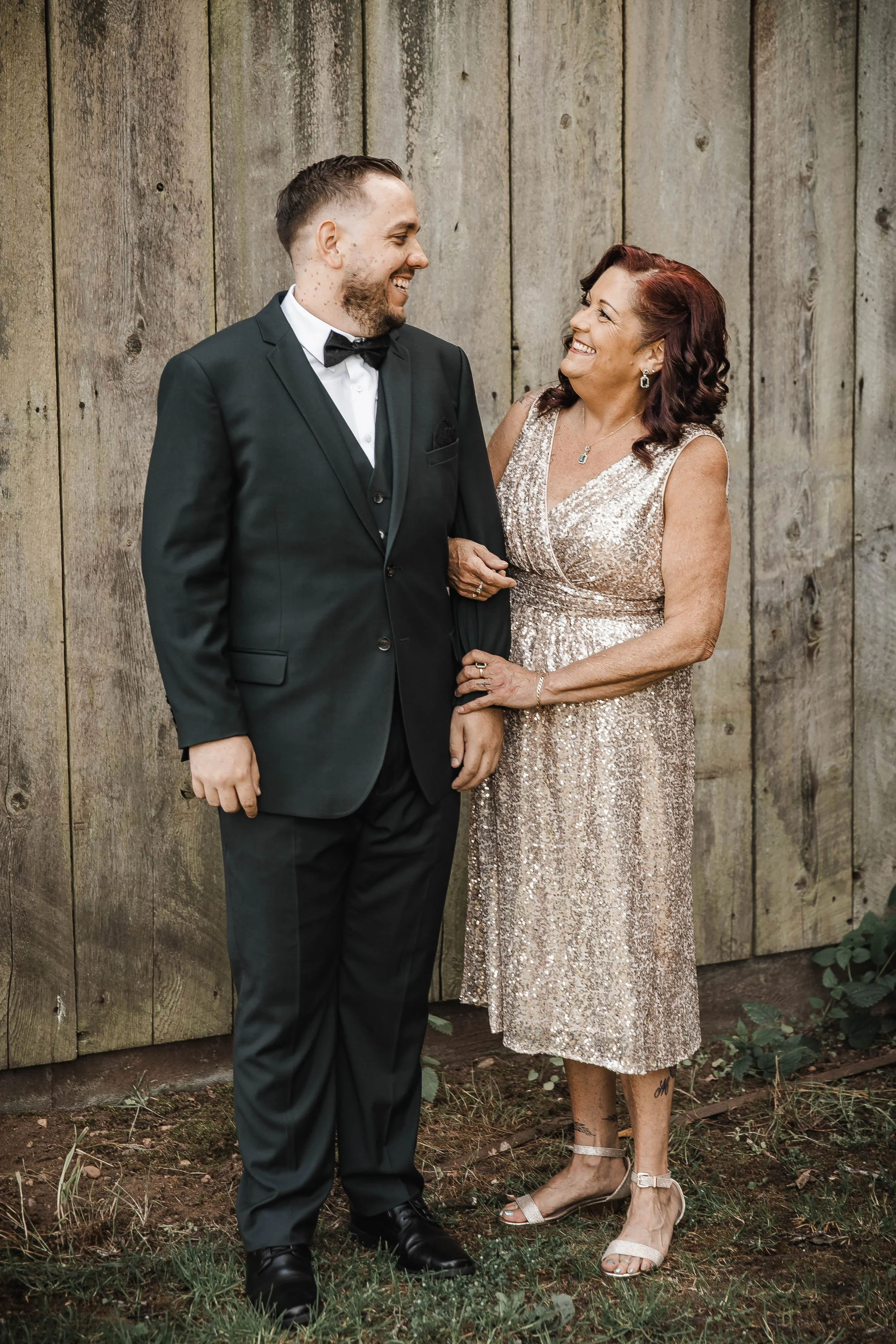 Groom sharing a joyful moment with his mother in front of a rustic wooden barn at Estate 248 in Aldergrove, BC.