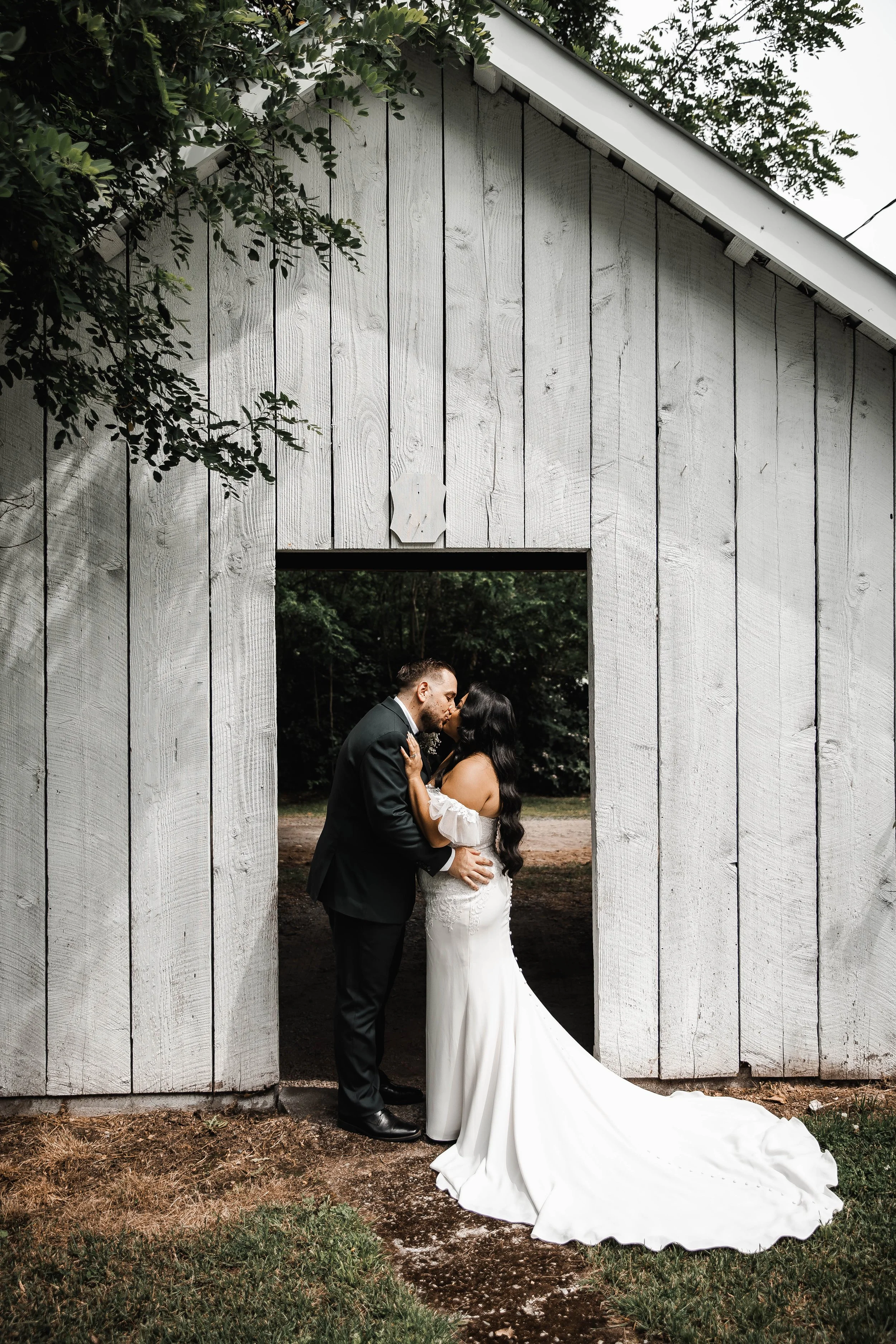 Newlyweds embracing beneath lush greenery during romantic wedding portraits at Estate 248 in the Fraser Valley.