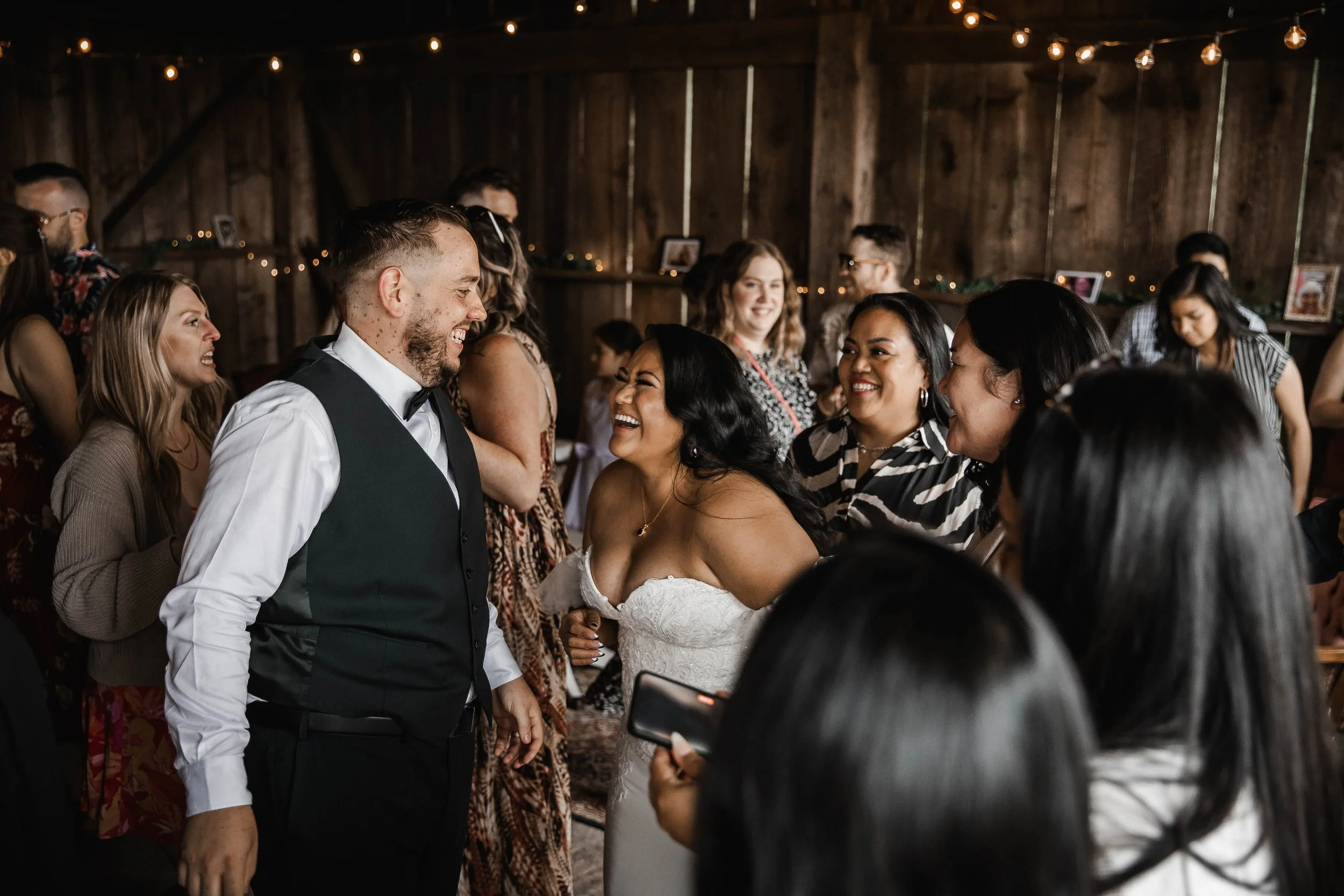 Newlyweds laughing with wedding guests during a candid reception moment at Estate 248 wedding venue in Aldergrove.