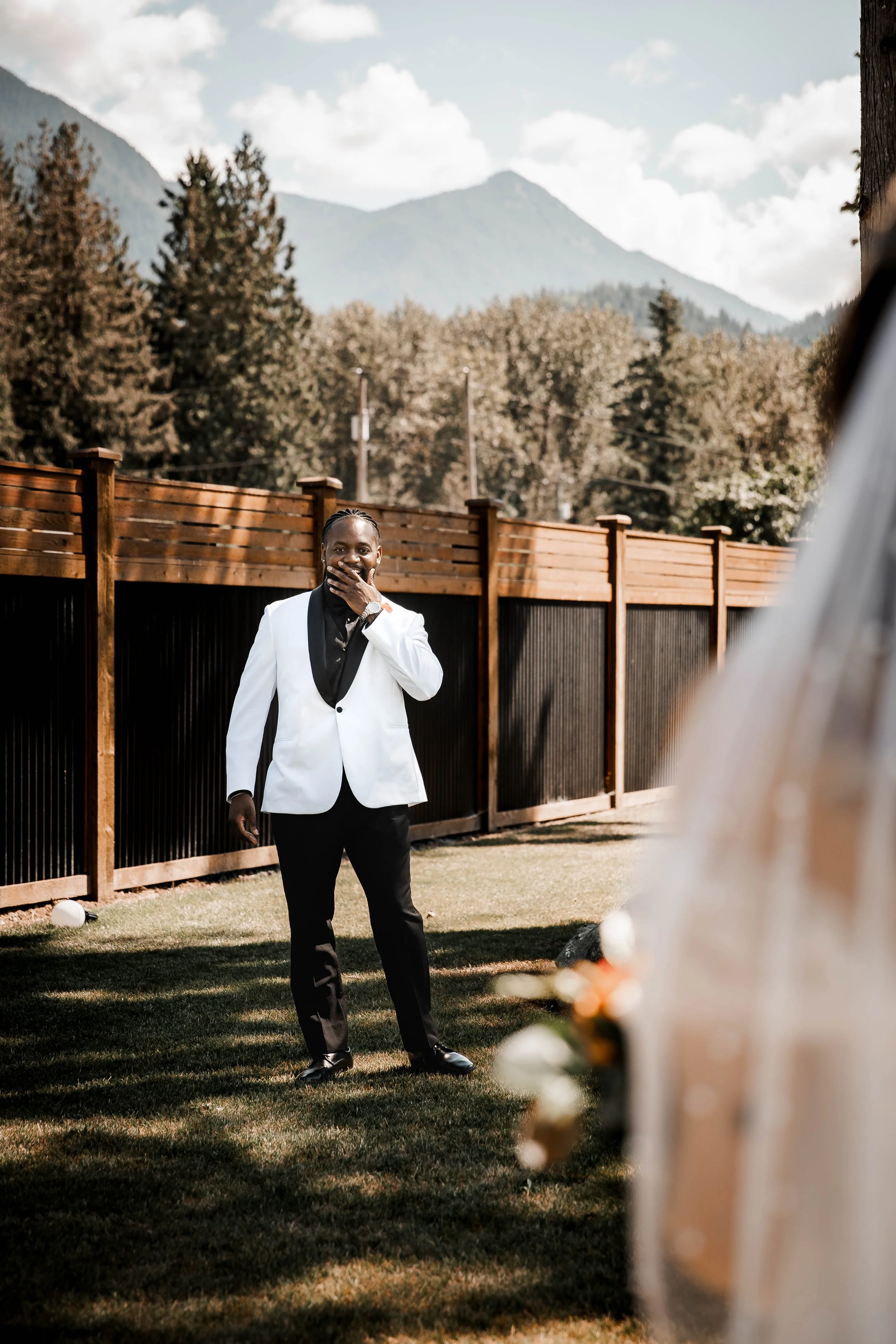 Bride holding a vibrant wedding bouquet as her emotional groom sees her for the first time at Bridlewoods in Chilliwack.
