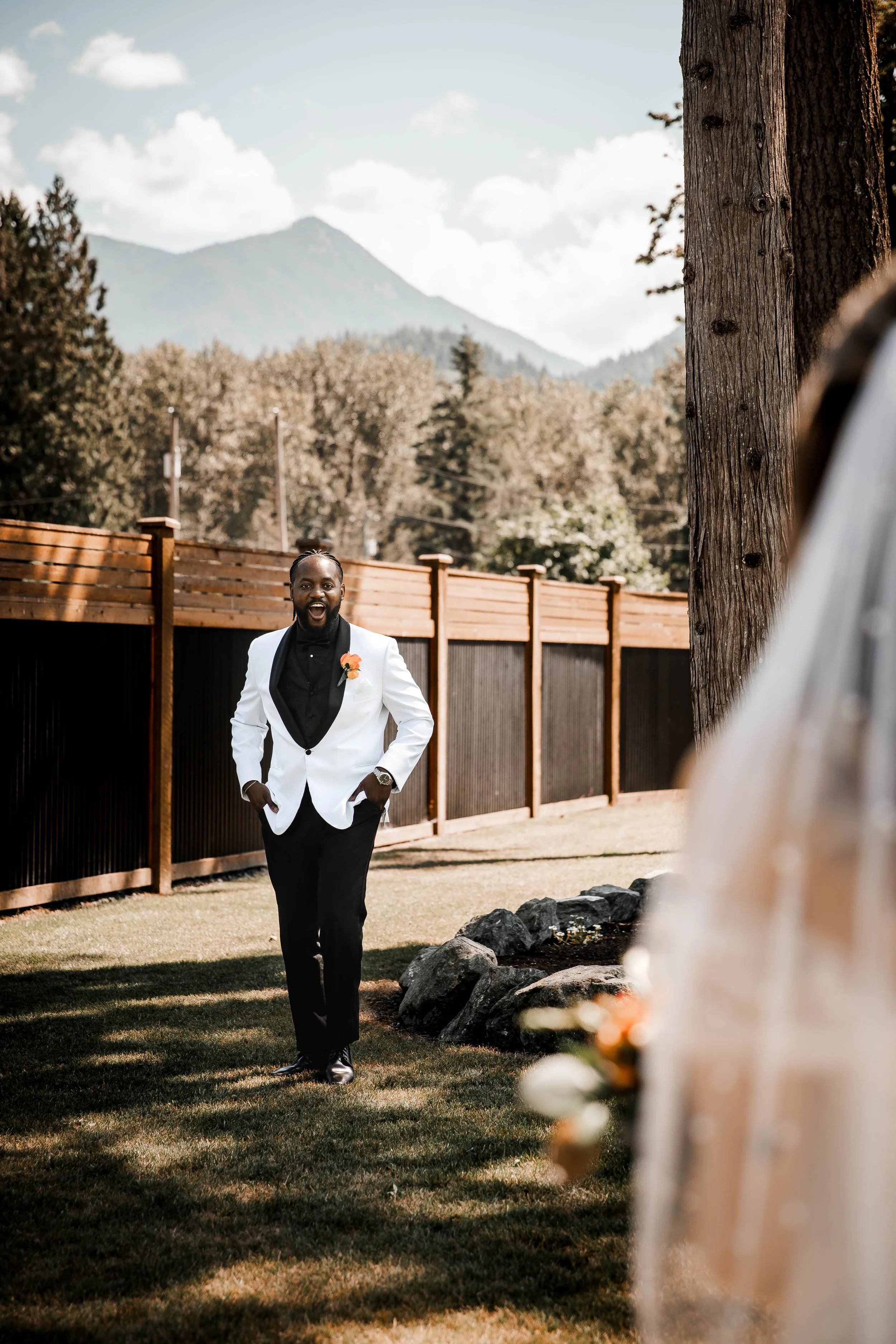 Groom wiping away tears beside the wedding officiant during an emotional outdoor ceremony at Bridlewoods in Chilliwack.