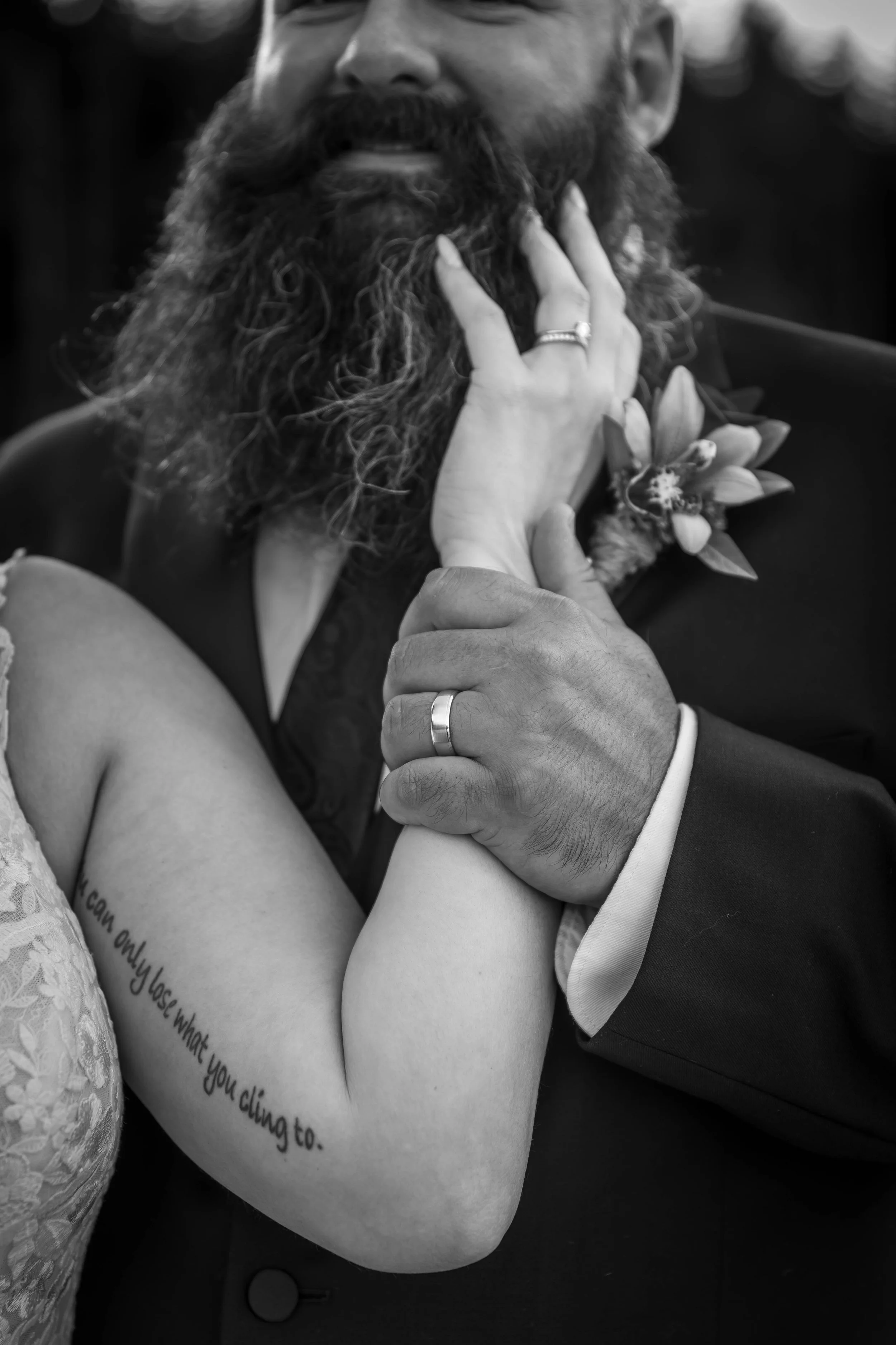 Emotional black and white close-up of newlyweds embracing, highlighting their wedding rings and a meaningful tattoo during their Whonnock Lake wedding in Maple Ridge, BC.
