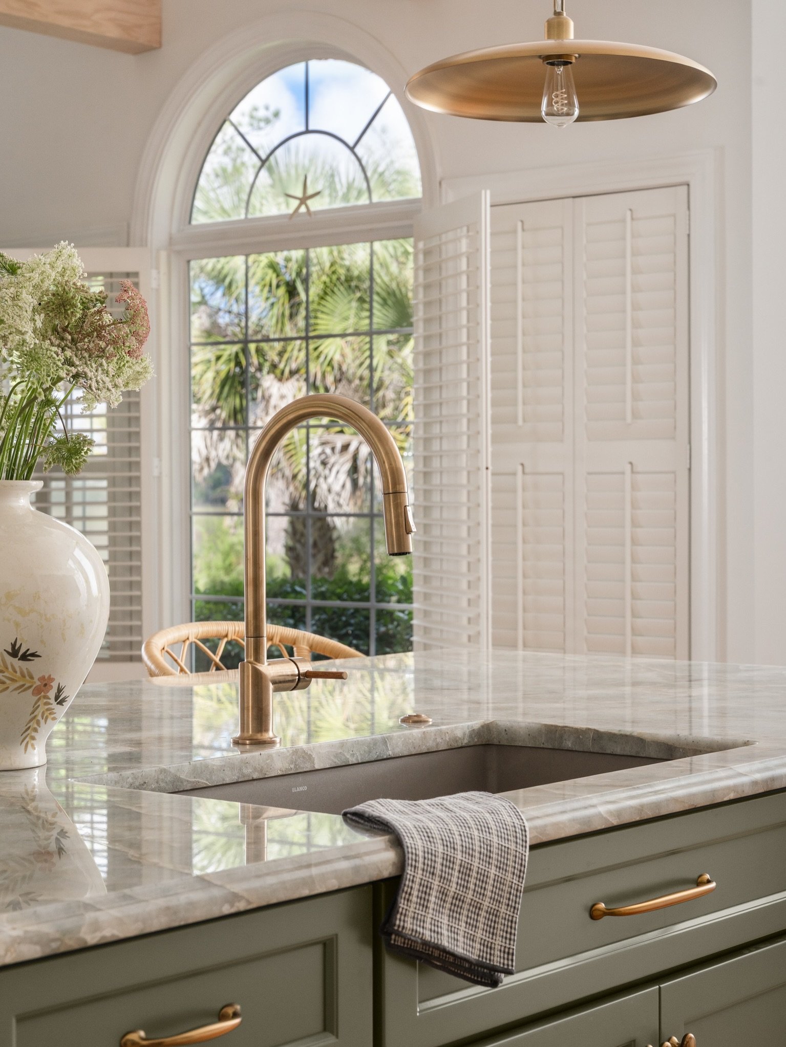 A kitchen renovation reimagined to take full advantage of the expansive marsh views, bringing functionality, warmth, and a renewed sense of openness to the heart of the home.

Richly veined Barcelona quartzite, a sculptural plaster hood, soft cream c