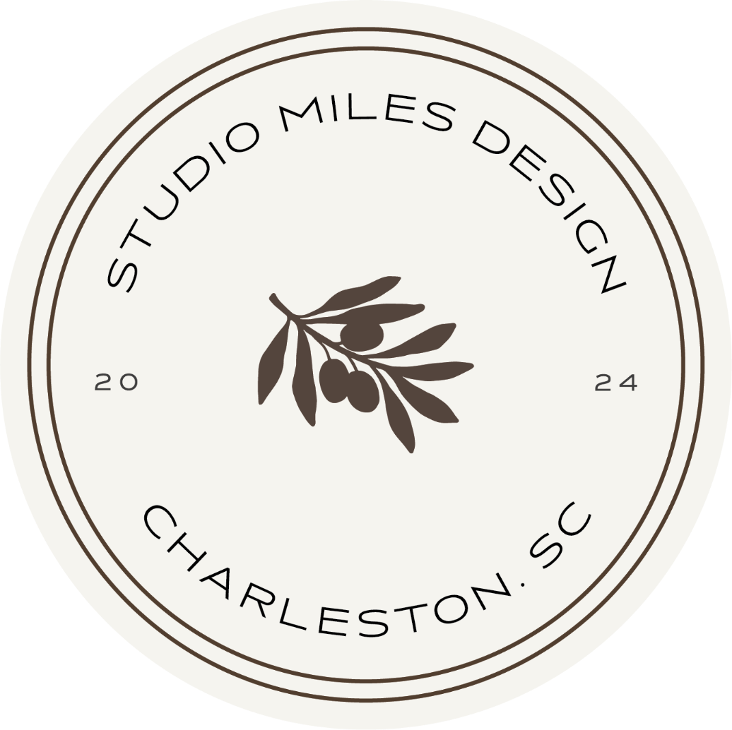 A circular logo with a beige background and dark brown text and illustration. It features an olive branch in the center and the words 'STUDIO MILES DESIGN' around the top, 'CHARLESTON, SC' around the bottom, and the years '2024' on each side.