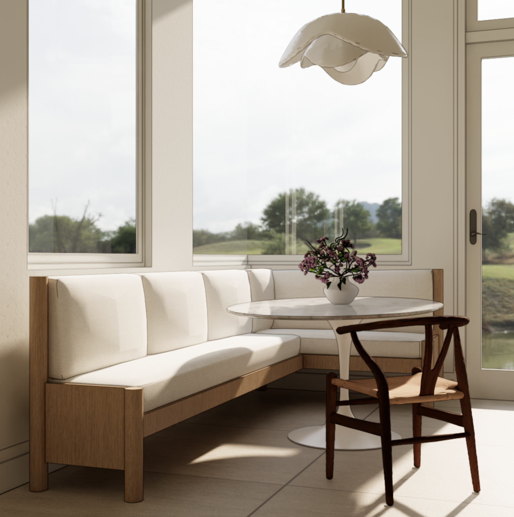 A bright dining area with a large window overlooking a green landscape. There is a wooden bench with a white cushion, a round white marble table, a wooden chair, a vase with purple flowers, and a hanging lampshade above.