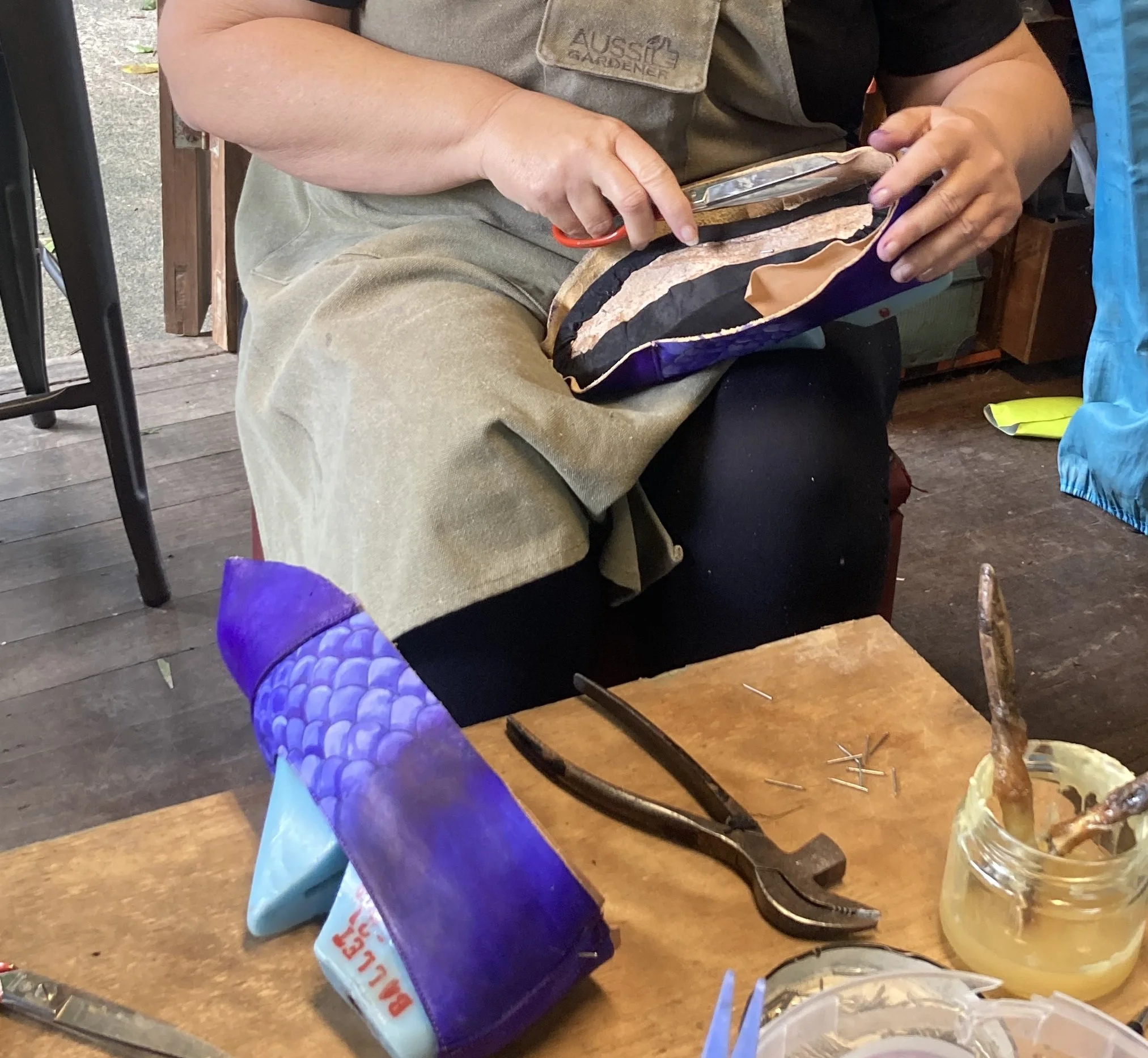 Handmaking shoes that are hand painted like dragon scales in purple