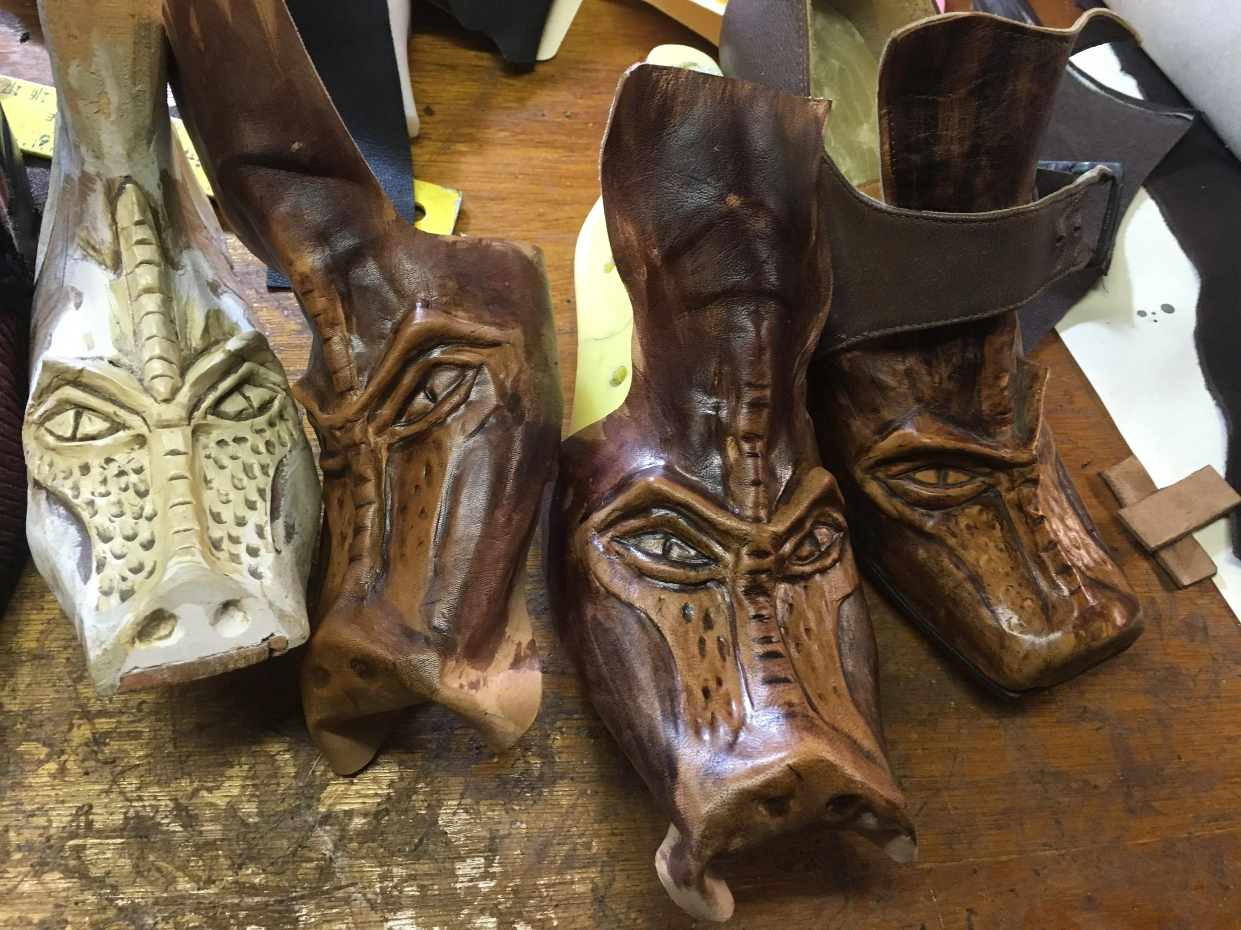 Hand-carved wooden masks with various facial designs displayed on a table.
