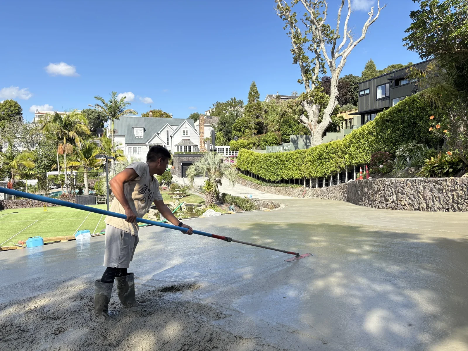 Concrete being placed along a curved residential driveway